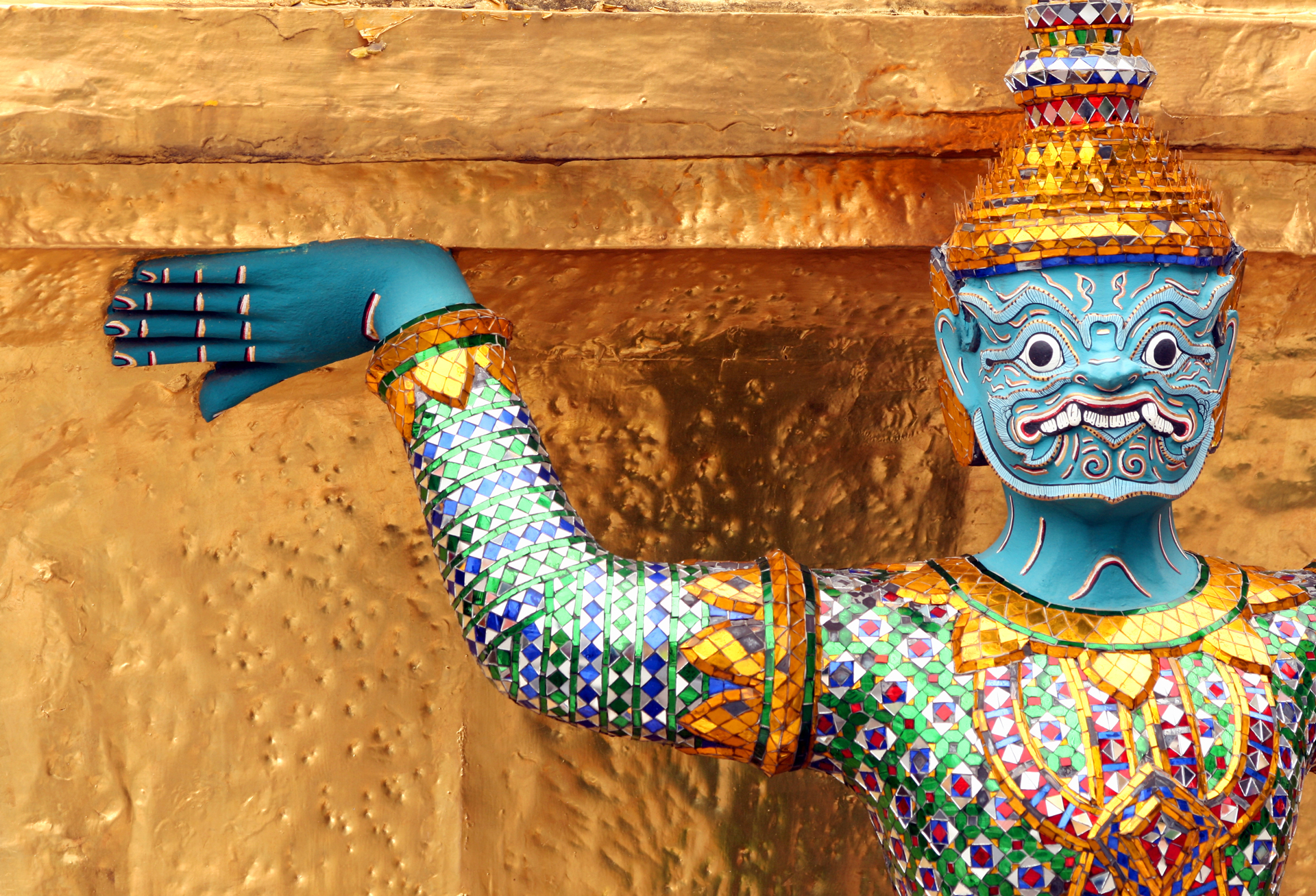 A Yakshas statue in a colourful design with a golden crown