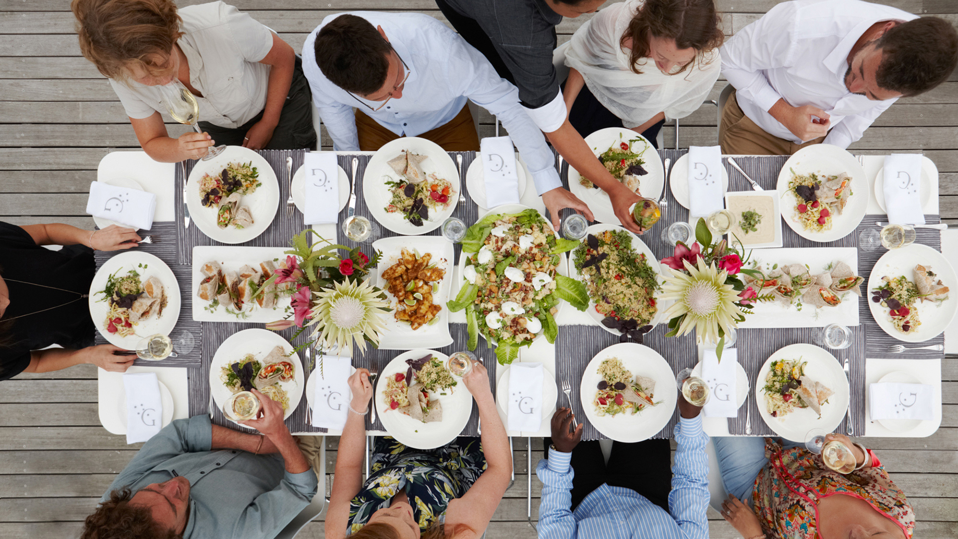 Above shot of eight people around a table of food