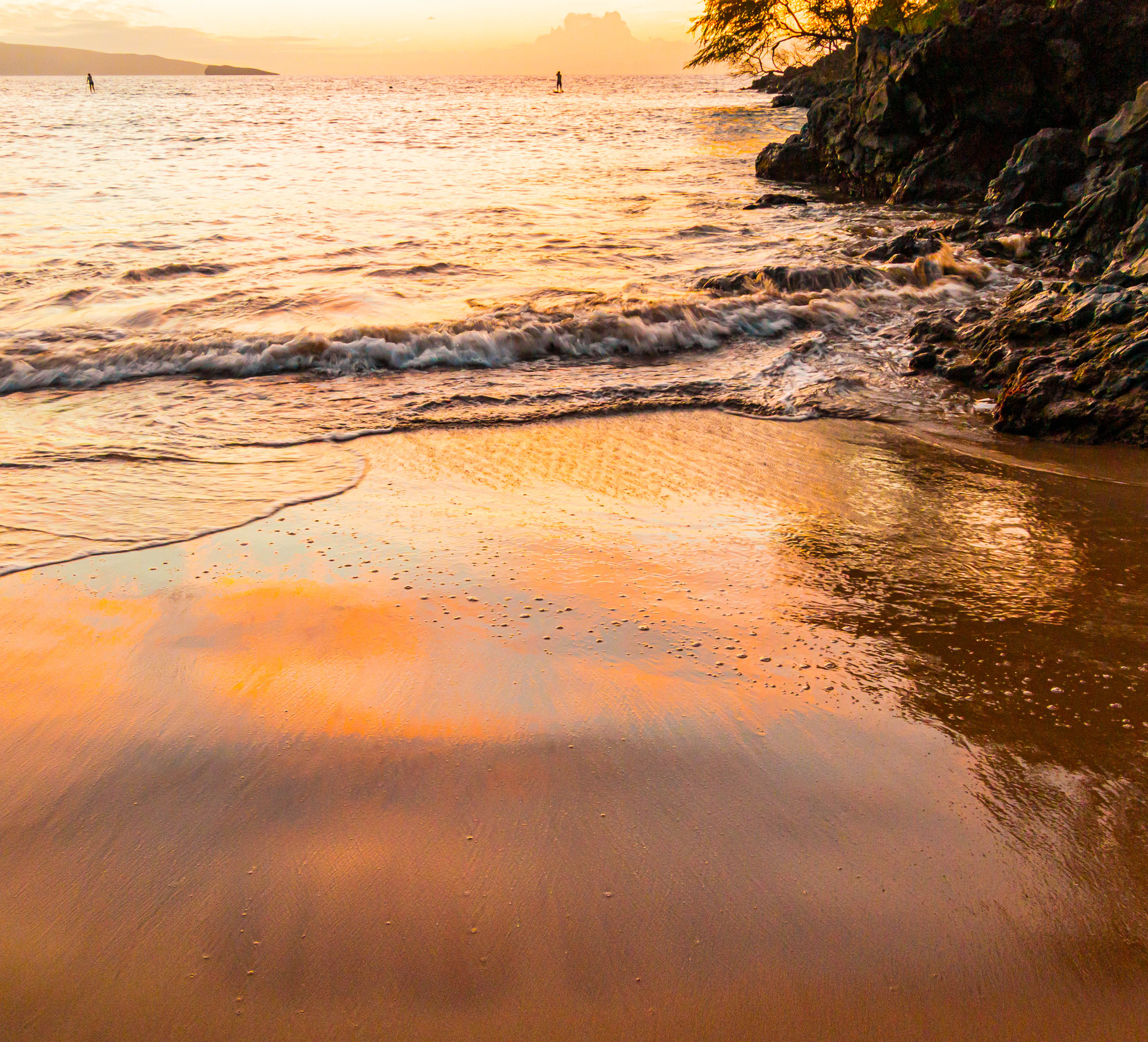 Golden sunset reflected on a tranquil Hawaiian beach