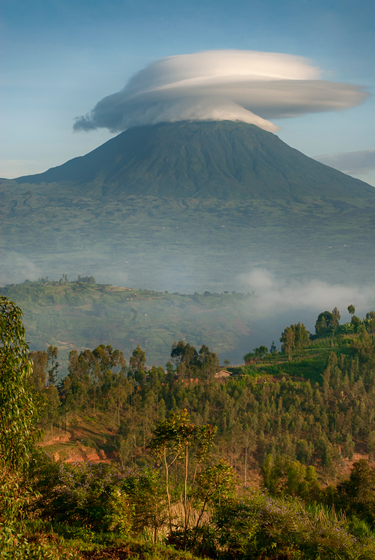 A big mountain with a cloud covering the top
