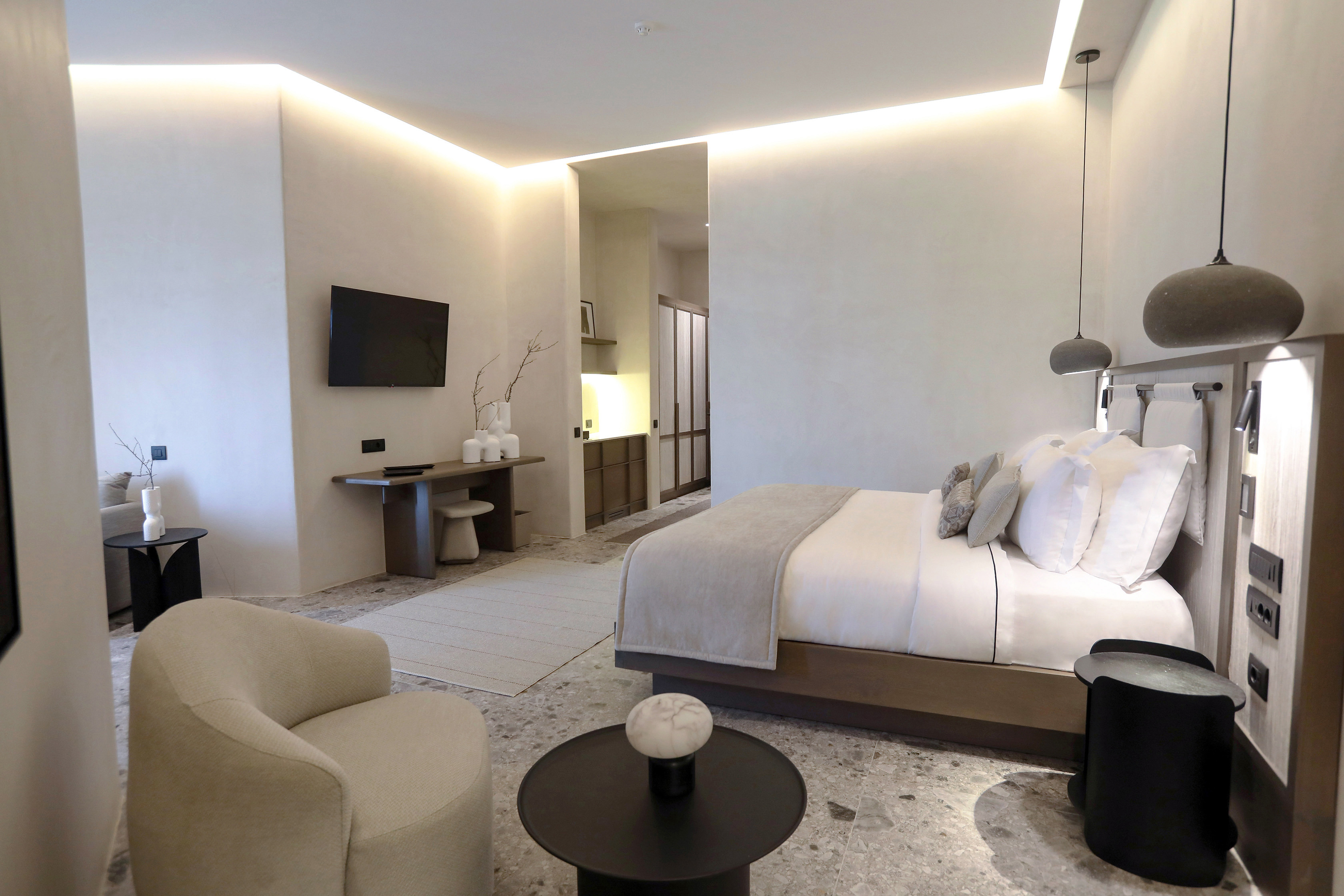 Interior of suite at Aeonic Suites & Spa with bed and lounge chair and table