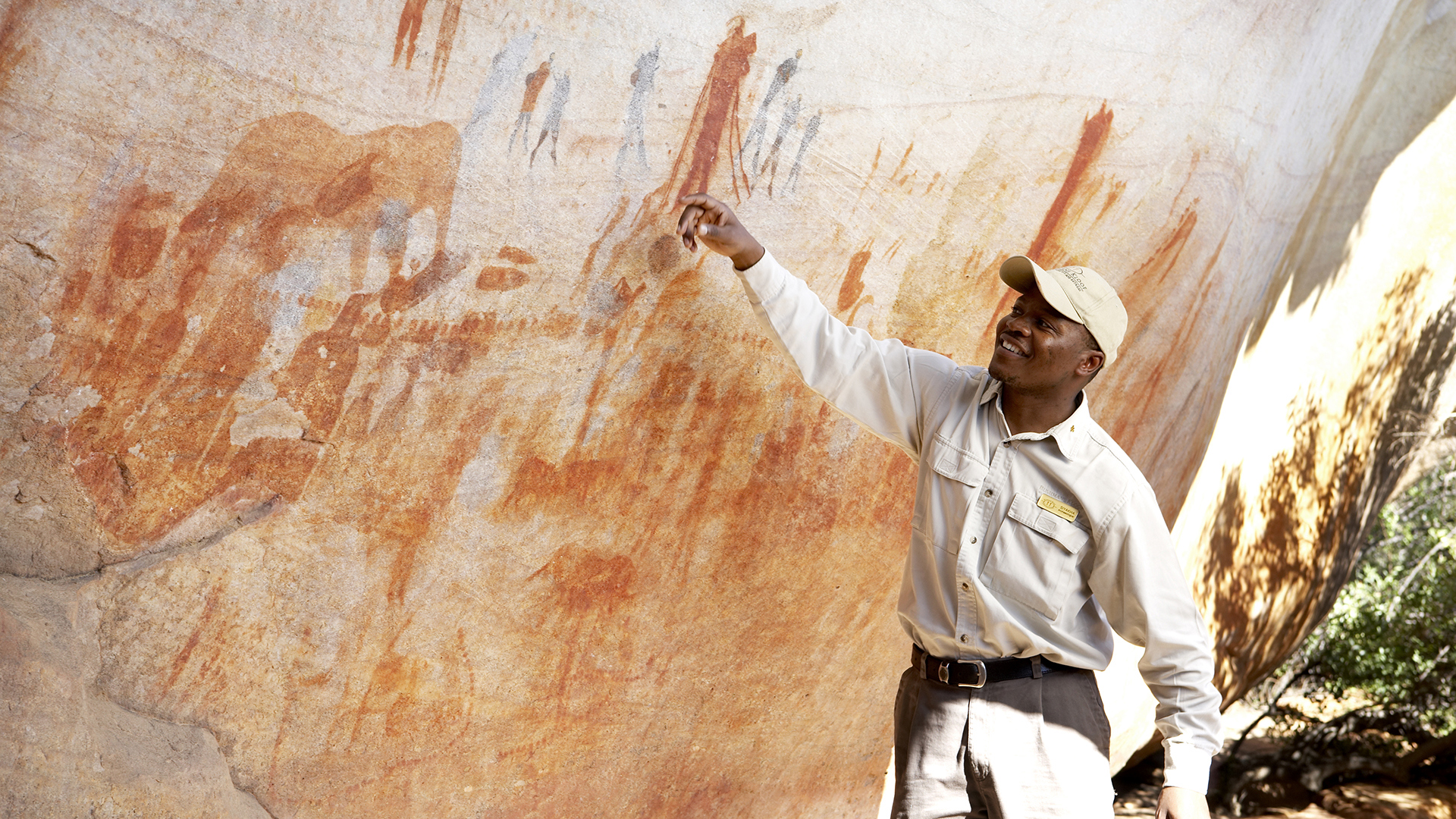 A guide points at rock art at Bushmans Kloof Wilderness Reserve and Wellness Retreat, Cape Town