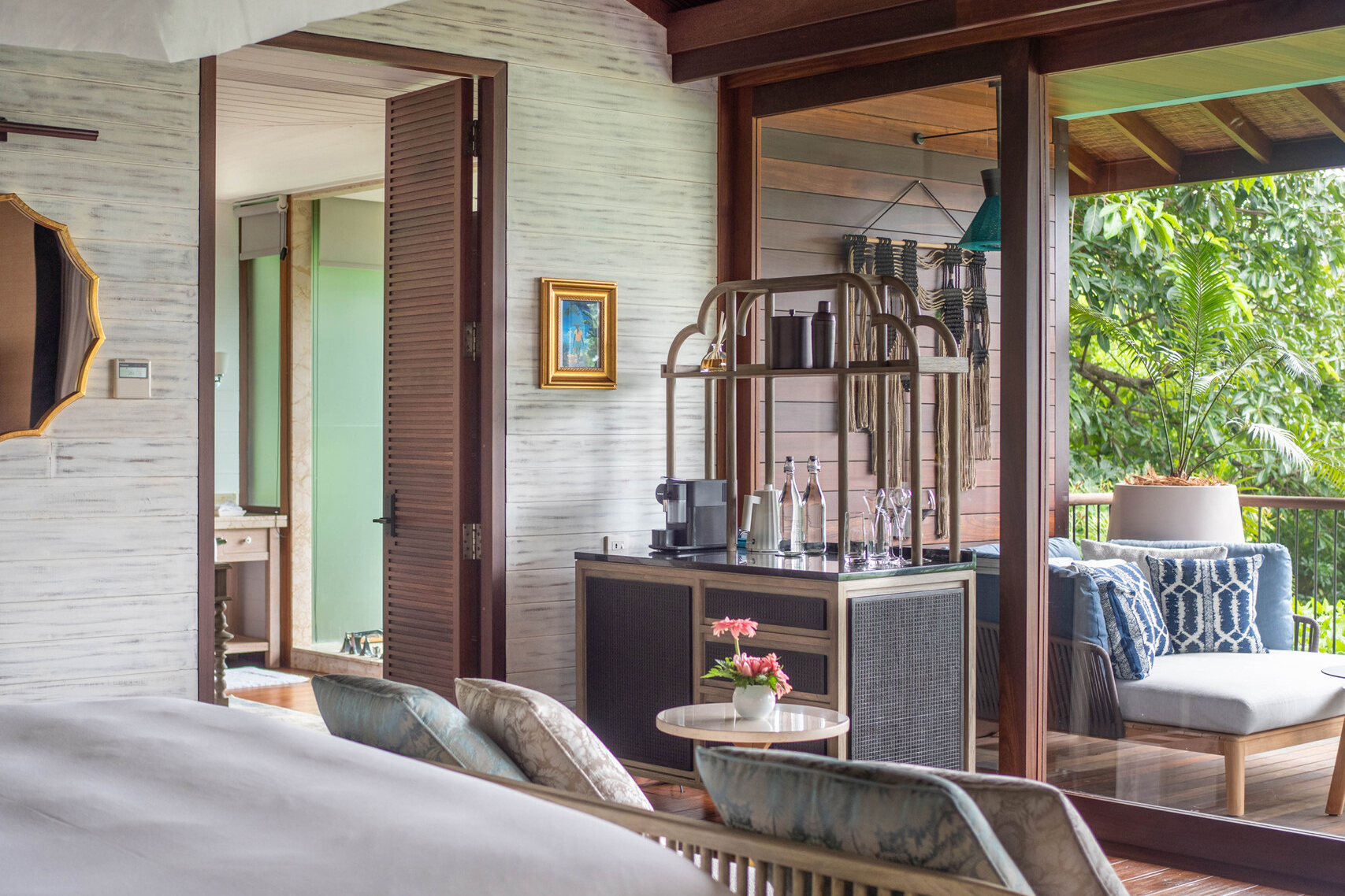 In-villa bar cart set between bathroom doorway and outdoor terrace