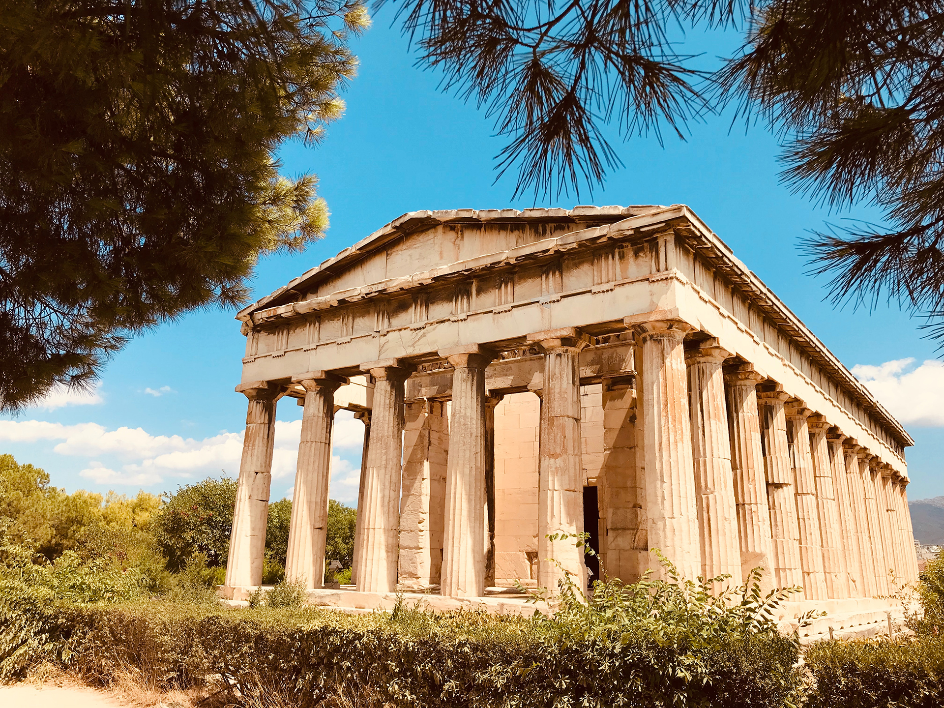 The Temple of Hephaestus - part of Agora surrounded by green bushes and trees