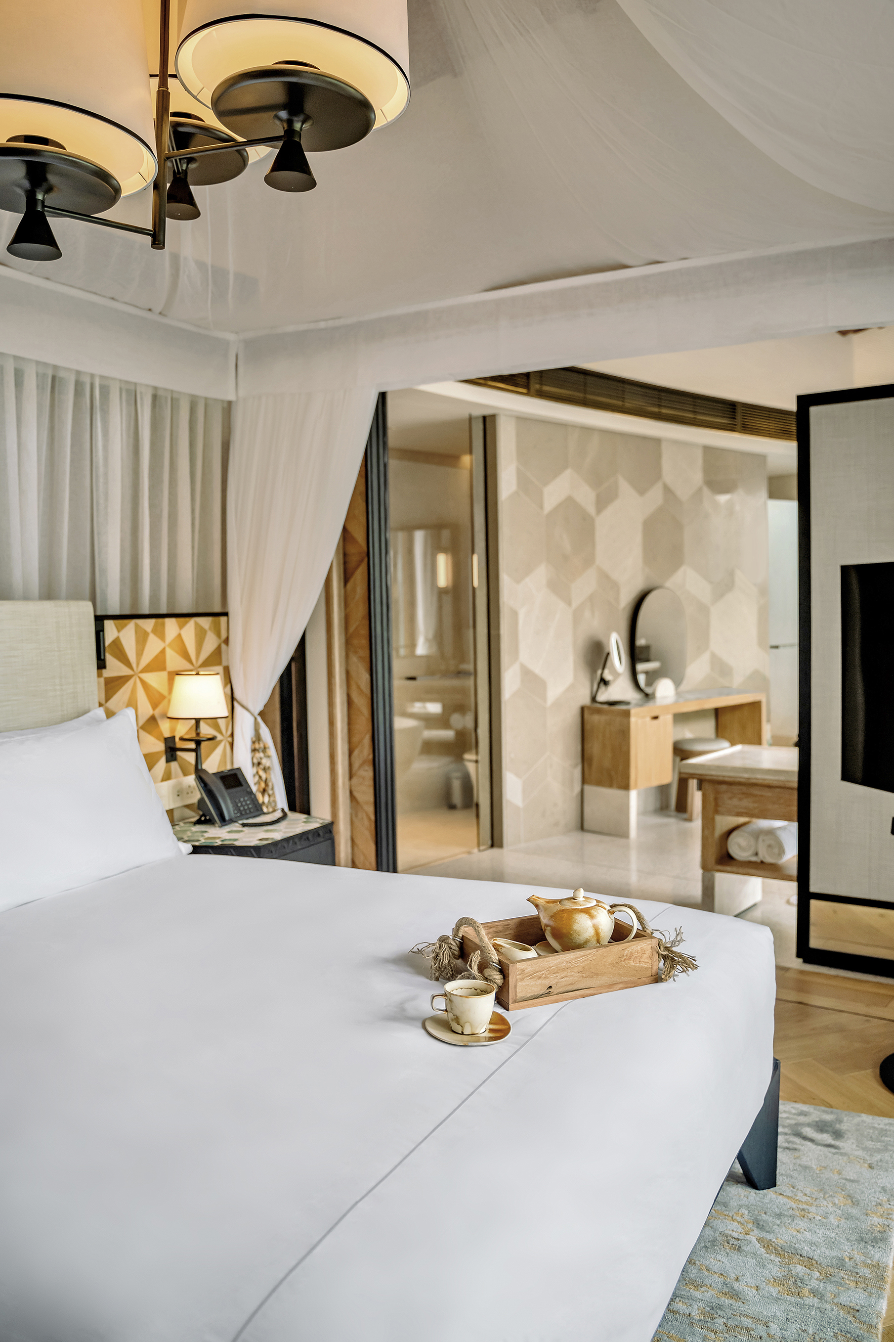 Teapot and cup laid on bed of pool villa