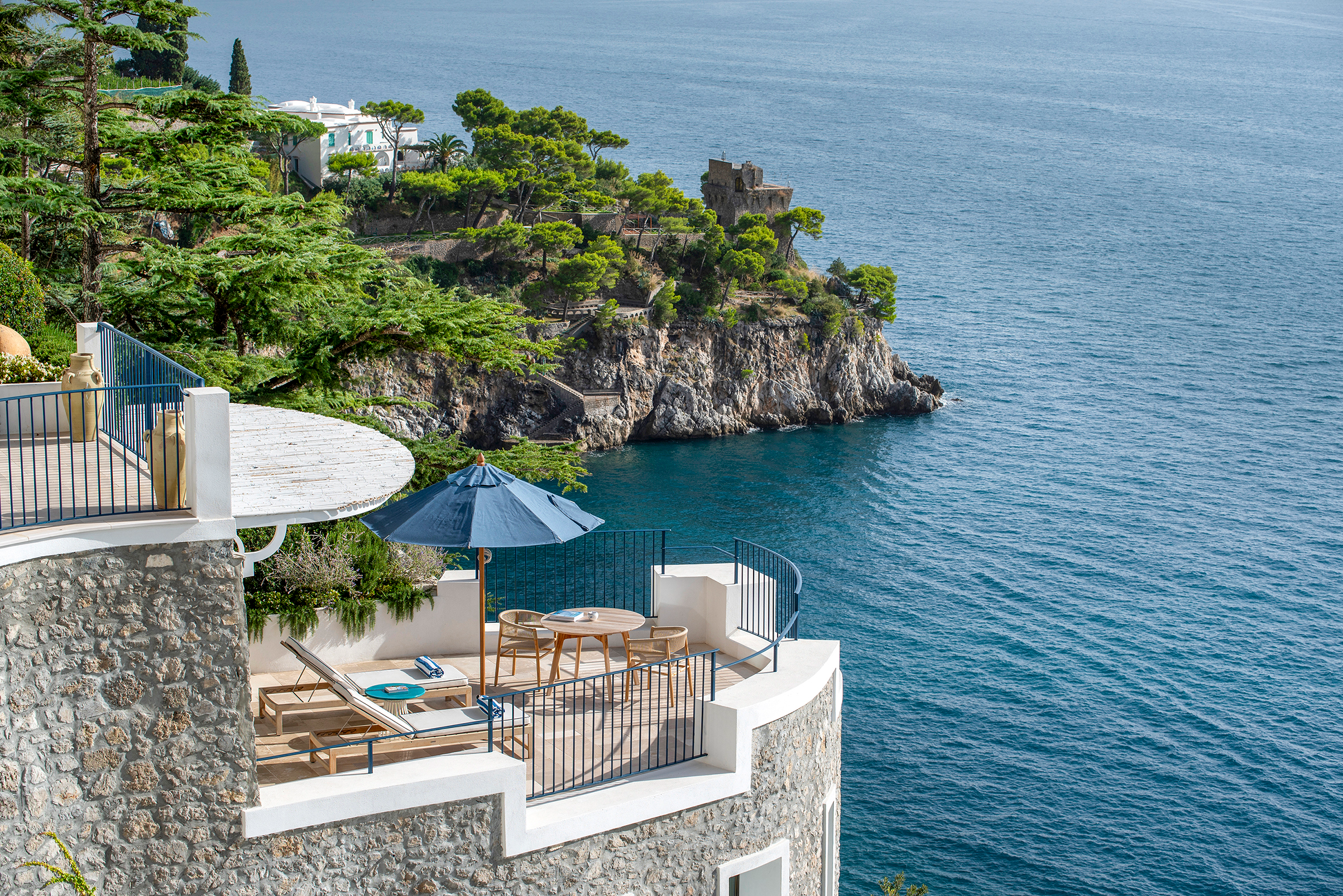 Deluxe suite terrace at Borgo Santandrea in Amalfi offering breathtaking views of the Mediterranean Sea and lush cliffside greenery.