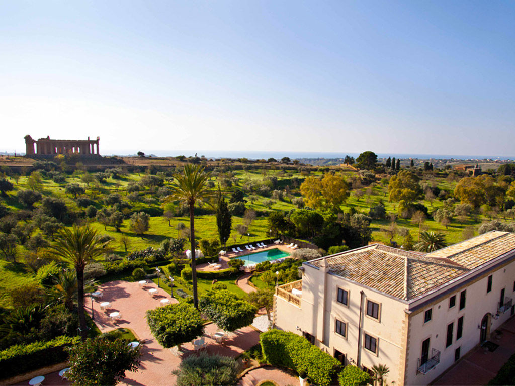 Europe, Italy, Sicily, Villa Athena resort, exterior view from above of villa and pool with the Temple of Concordia in the distance
