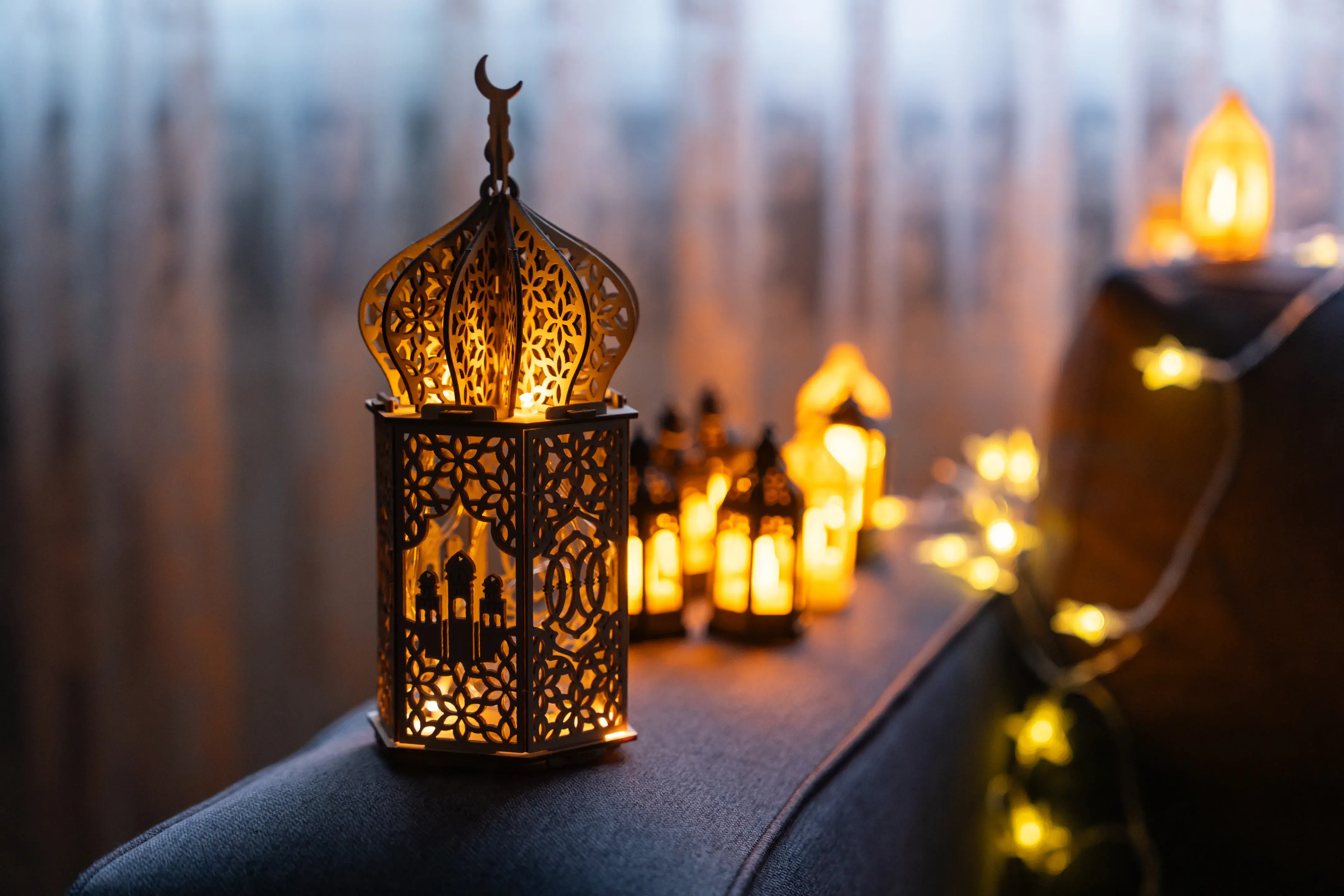Decorative Moroccan-style lanterns glowing with warm light and surrounded by string fairy lights.