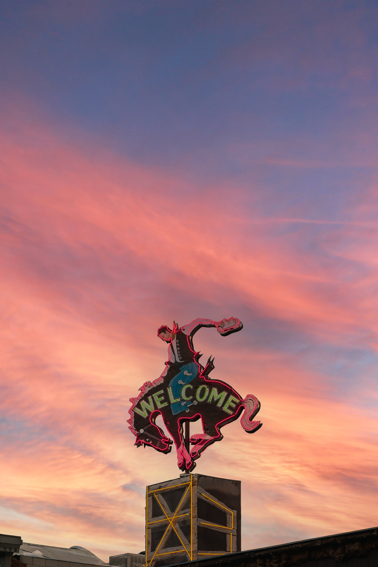 A neon welcome sign with a cowboy on a horse