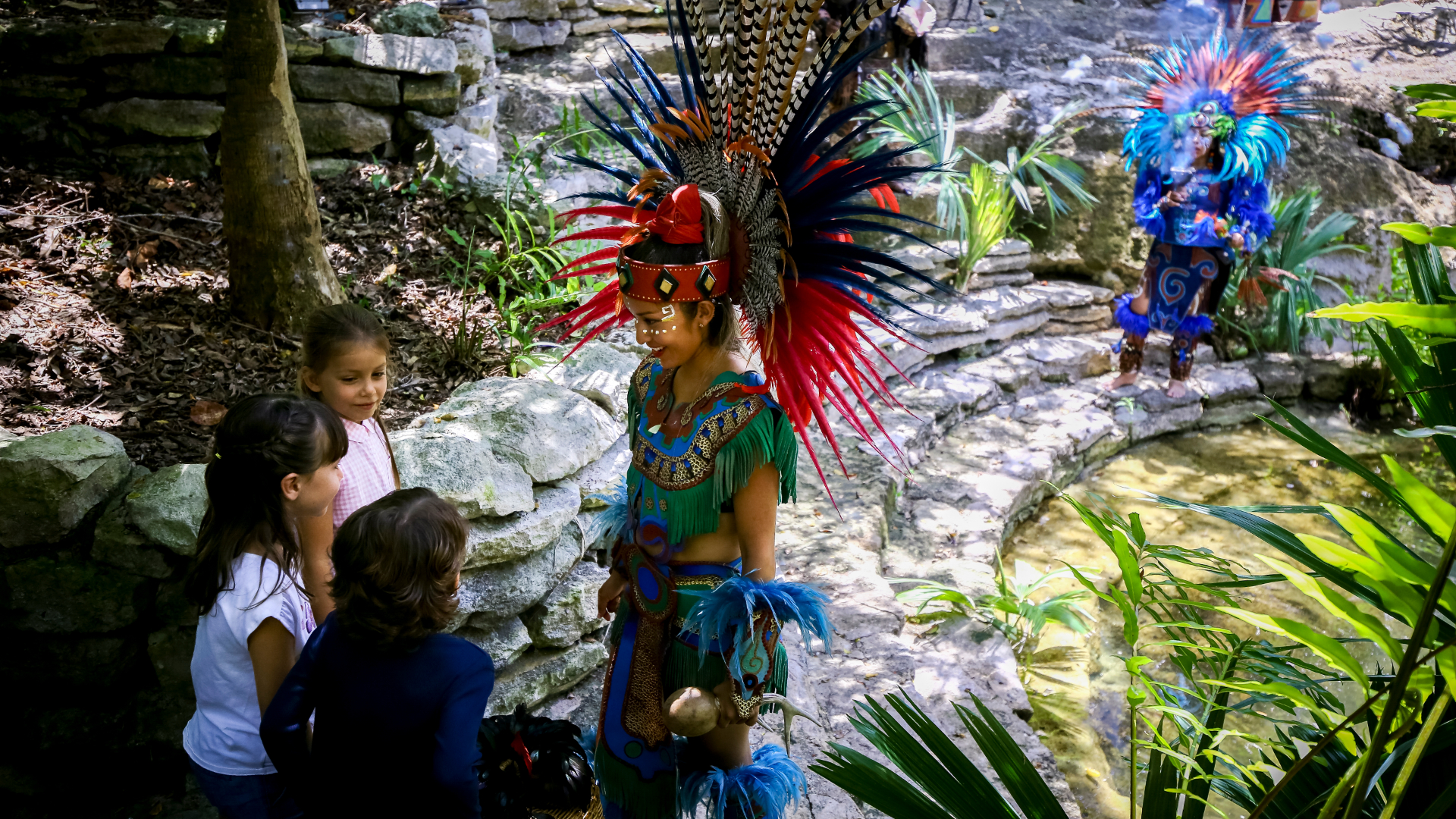 A woman wearing traditional Mexican clothing with a feather headdress 