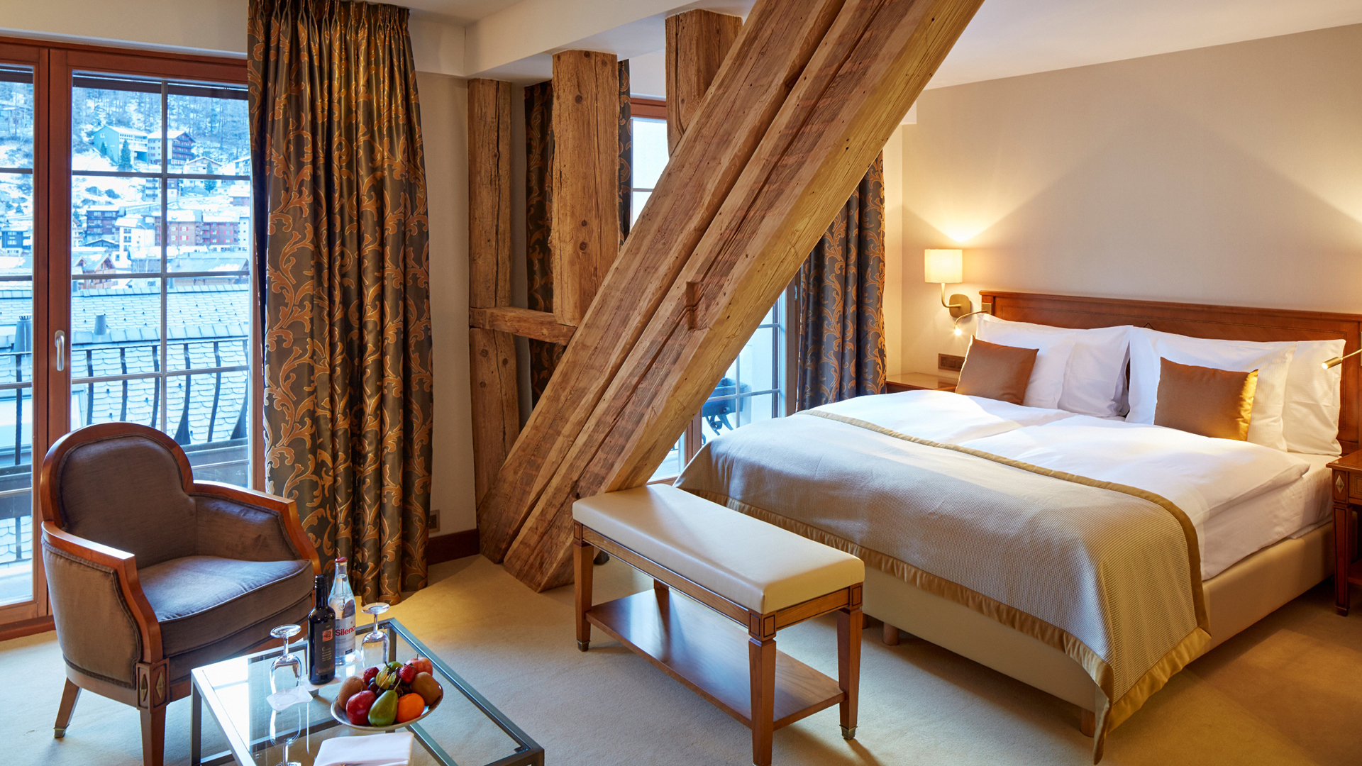A suite with wooden beam details featuring furniture and large windows