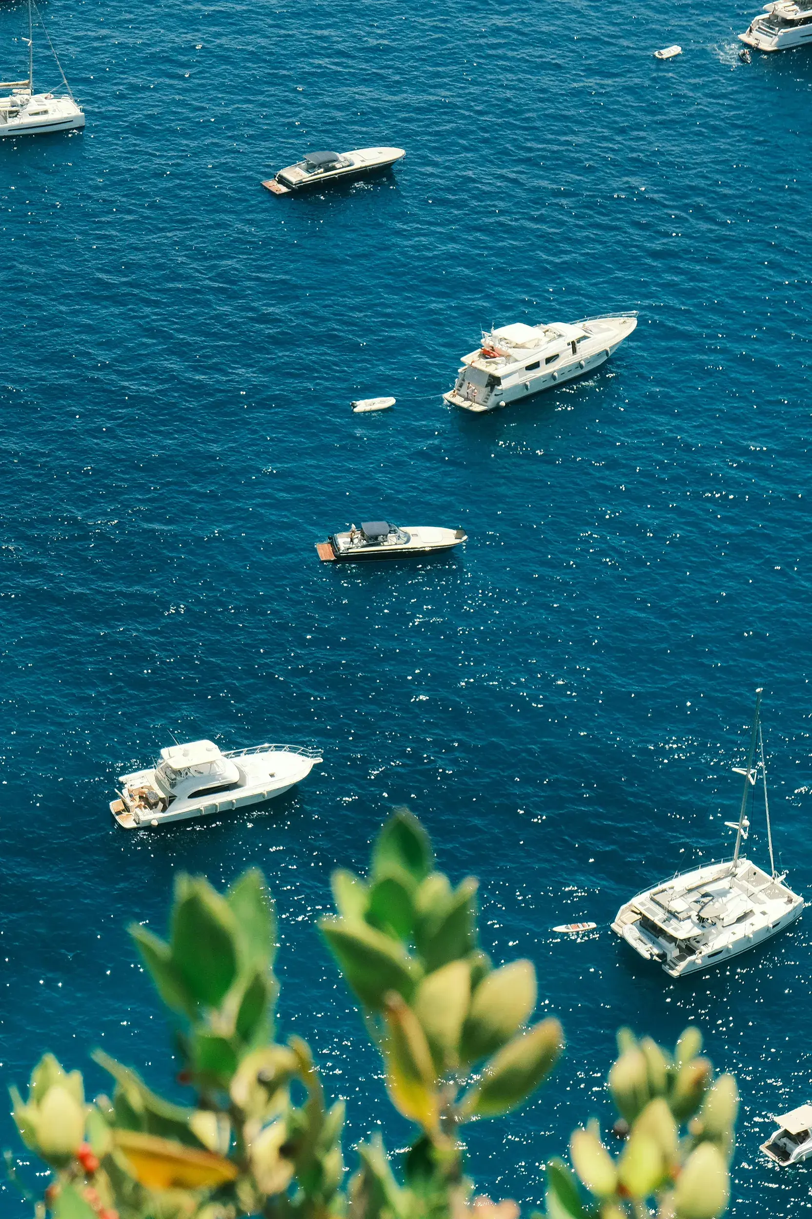 Luxury yachts and boats floating on the clear blue waters of the Amalfi Coast in Italy.