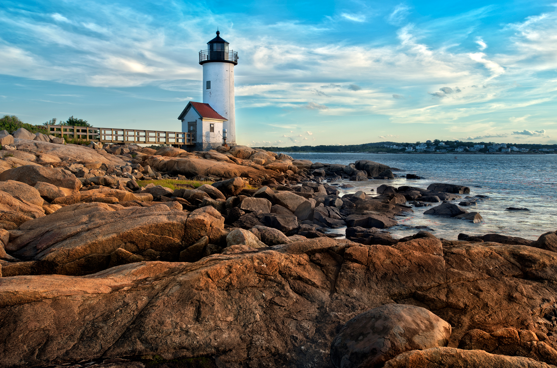 Small white lighthouse on a rocky shoreline