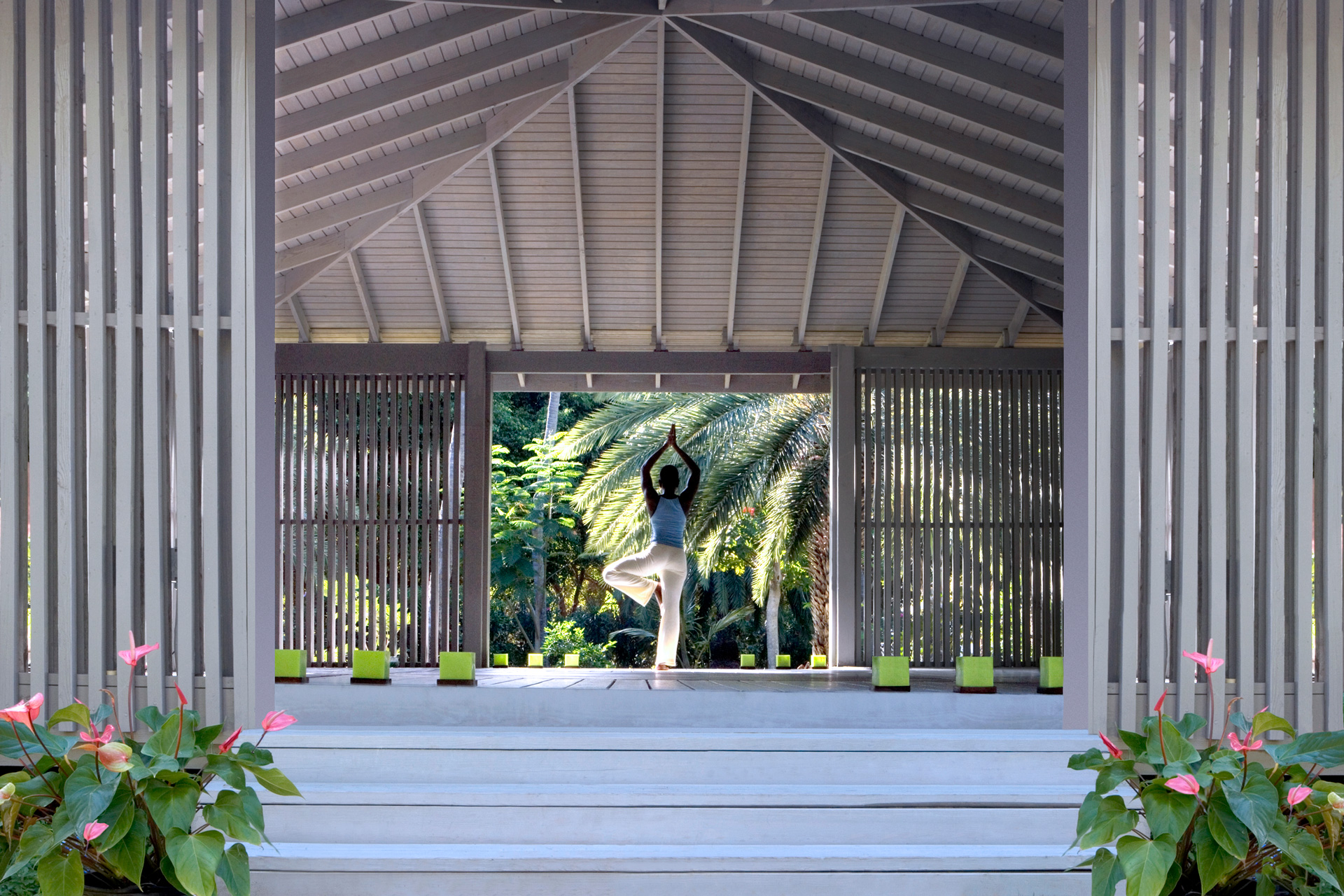 A woman doing yoga in a wooden pavilion
