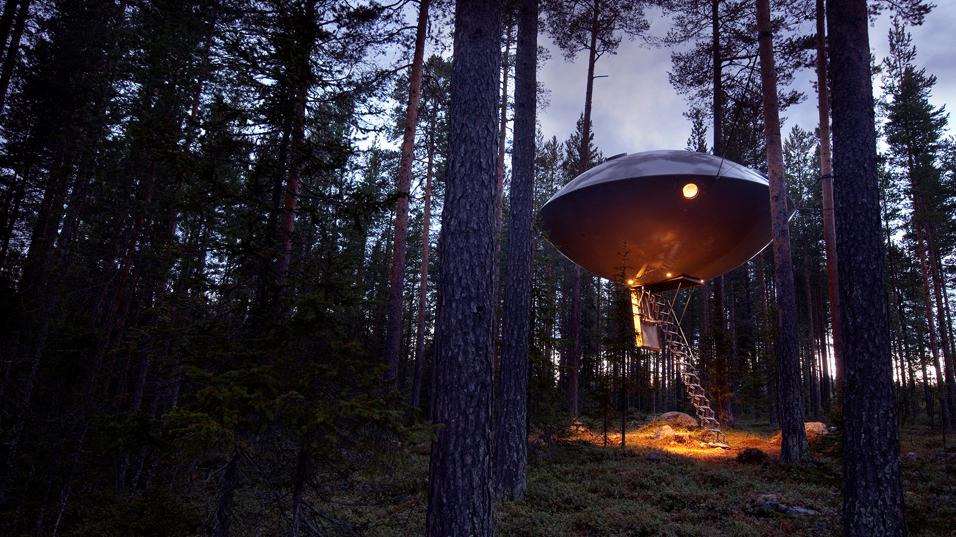 A metallic round room resembling a ufo at Treehotel accommodation in Sweden 