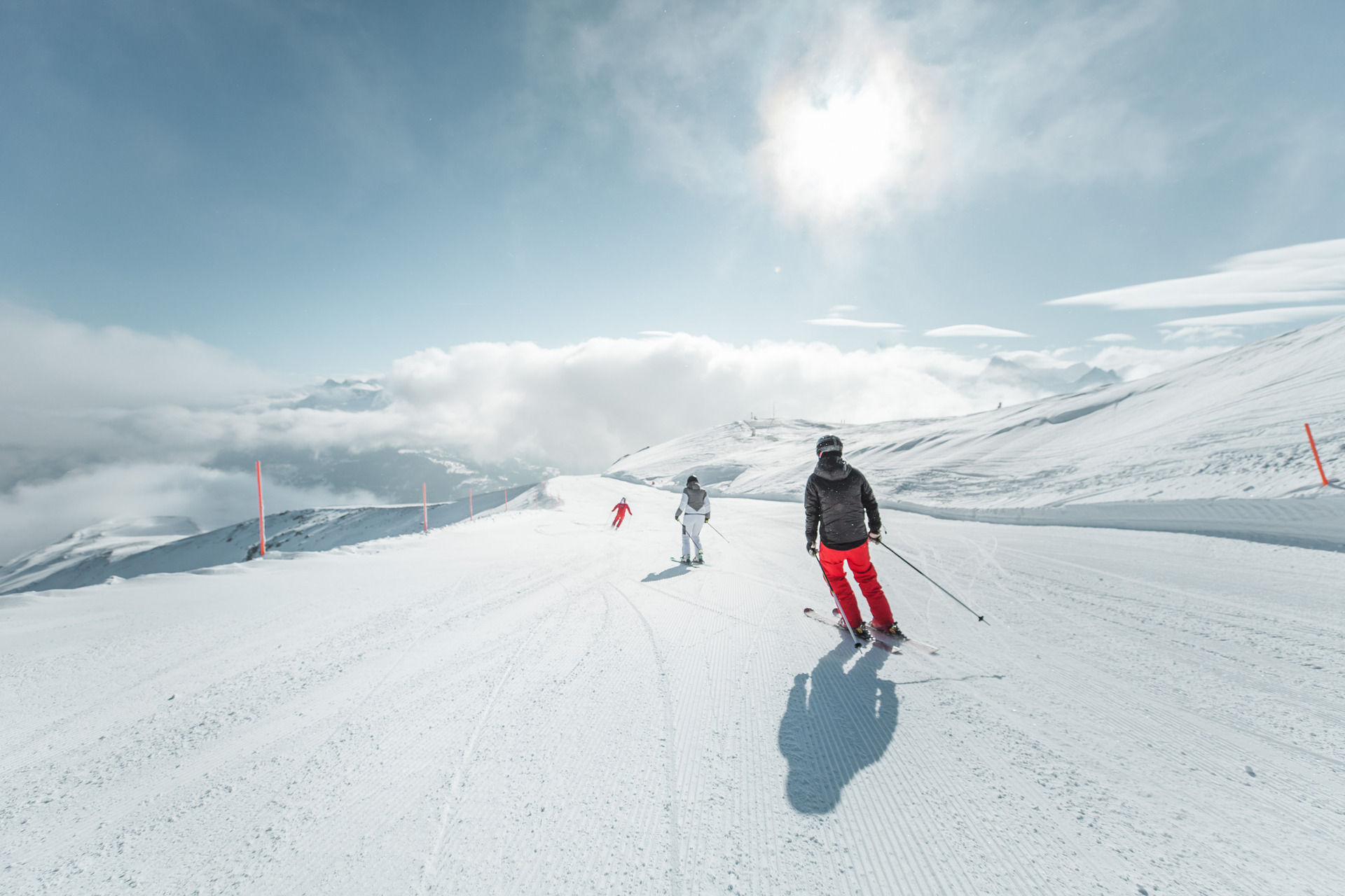 Three skiers going along a flat ski route