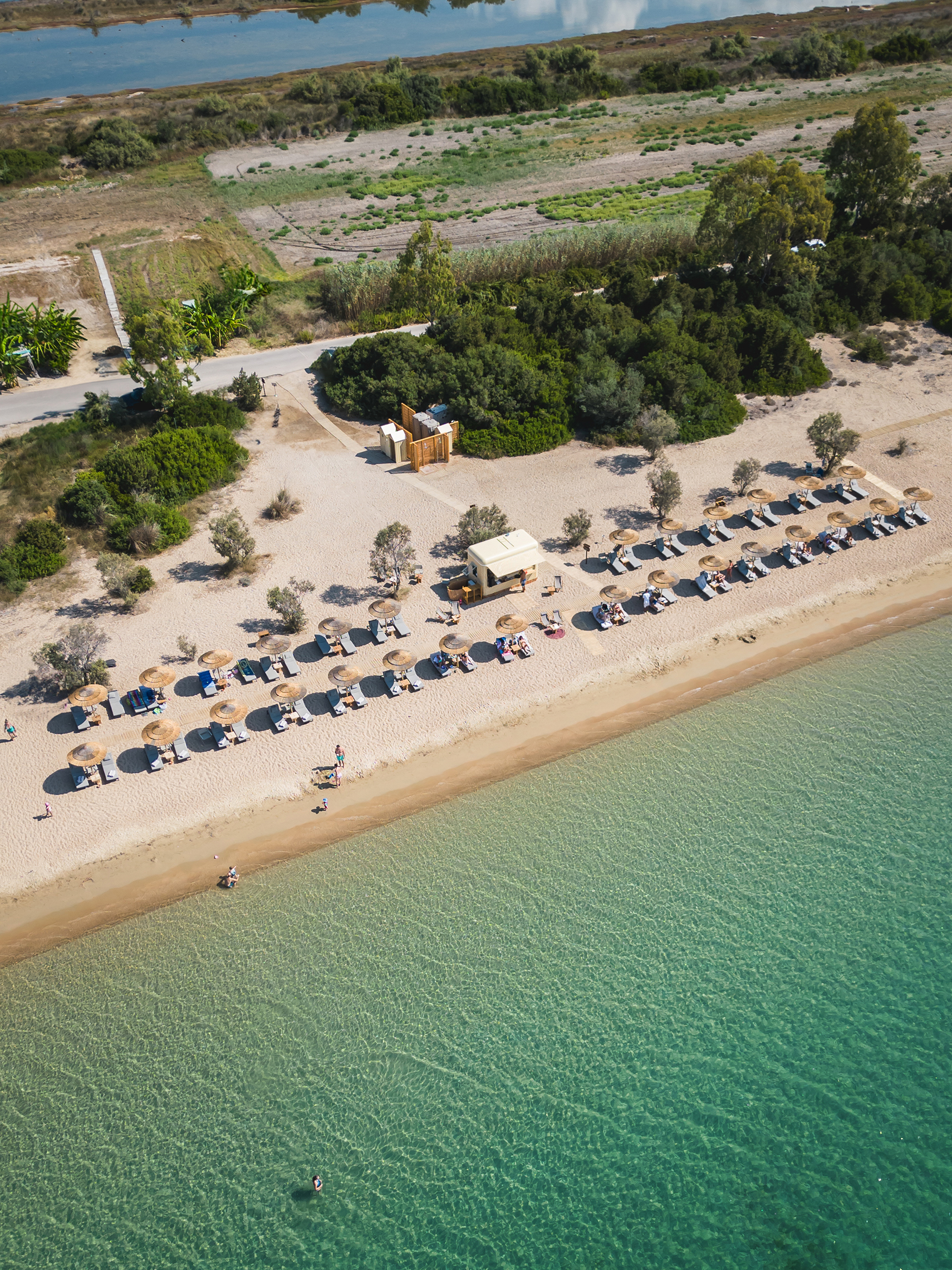 Aerial view of the beach at W Costa Navarino with guests on loungers and in the ocean