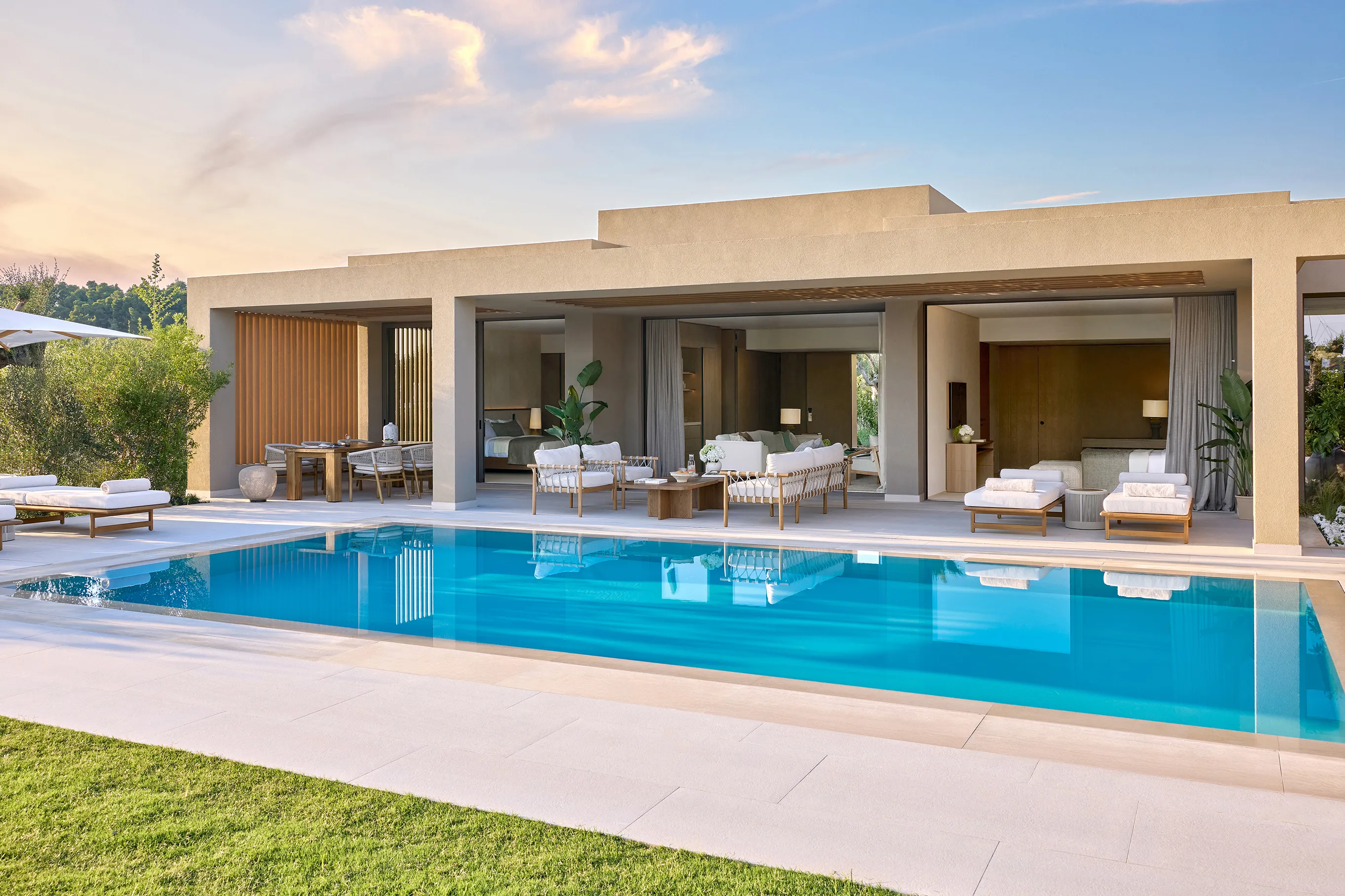 Luxury private‑pool villa at Sani Asterias in Halkidiki featuring elegant open‑plan living spaces and a spacious terrace overlooking the garden.