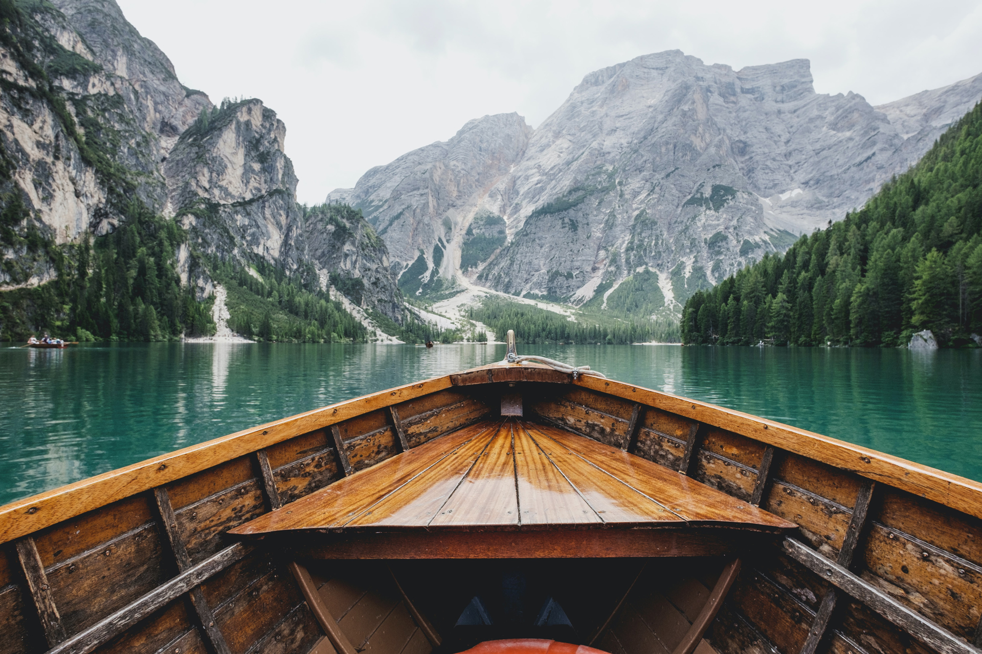 View from a brown wooden rowing boat on a lake looking towards mountains