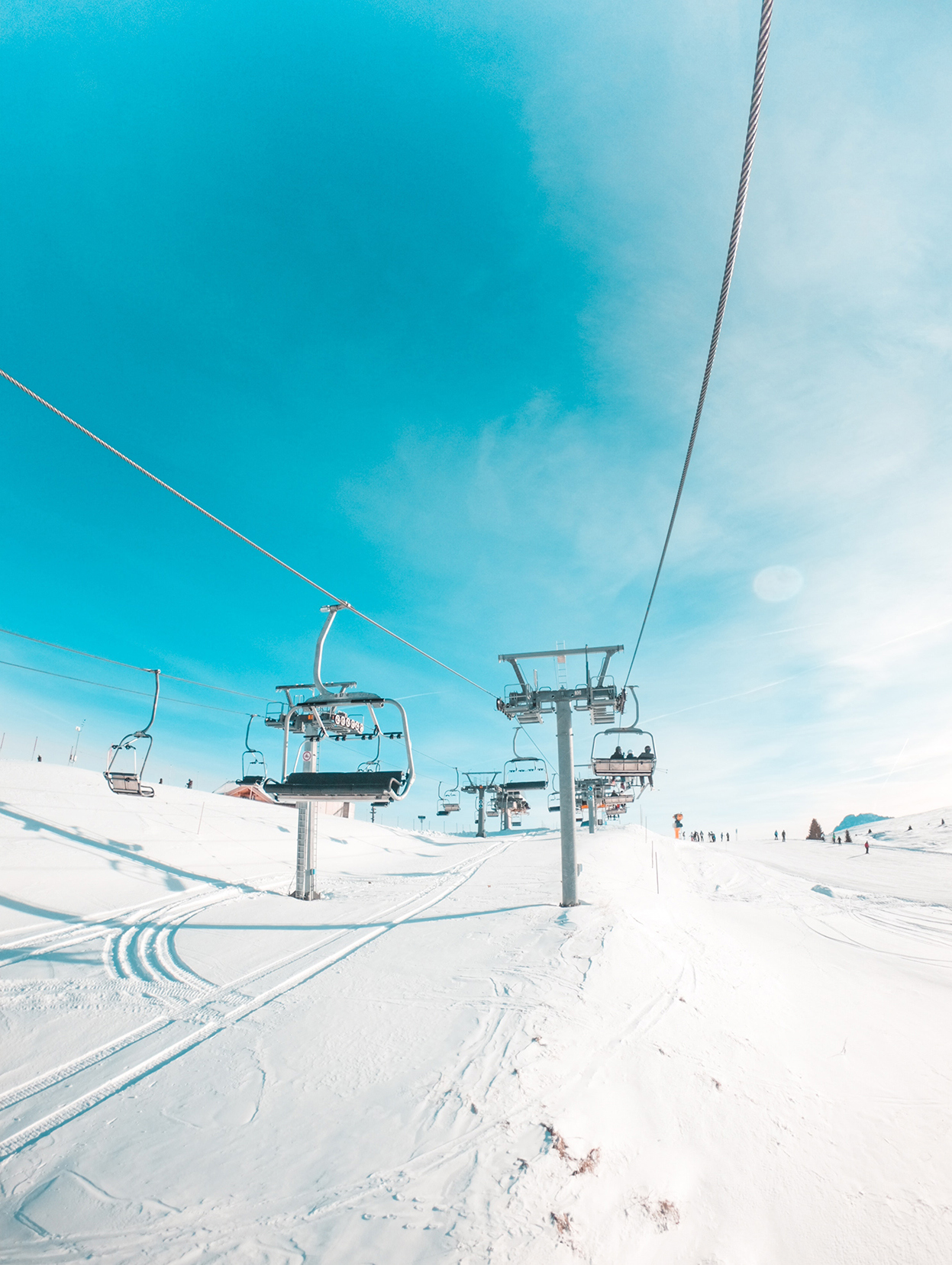 View from on a cable car as skiers go to the hilltop in the Dolomites