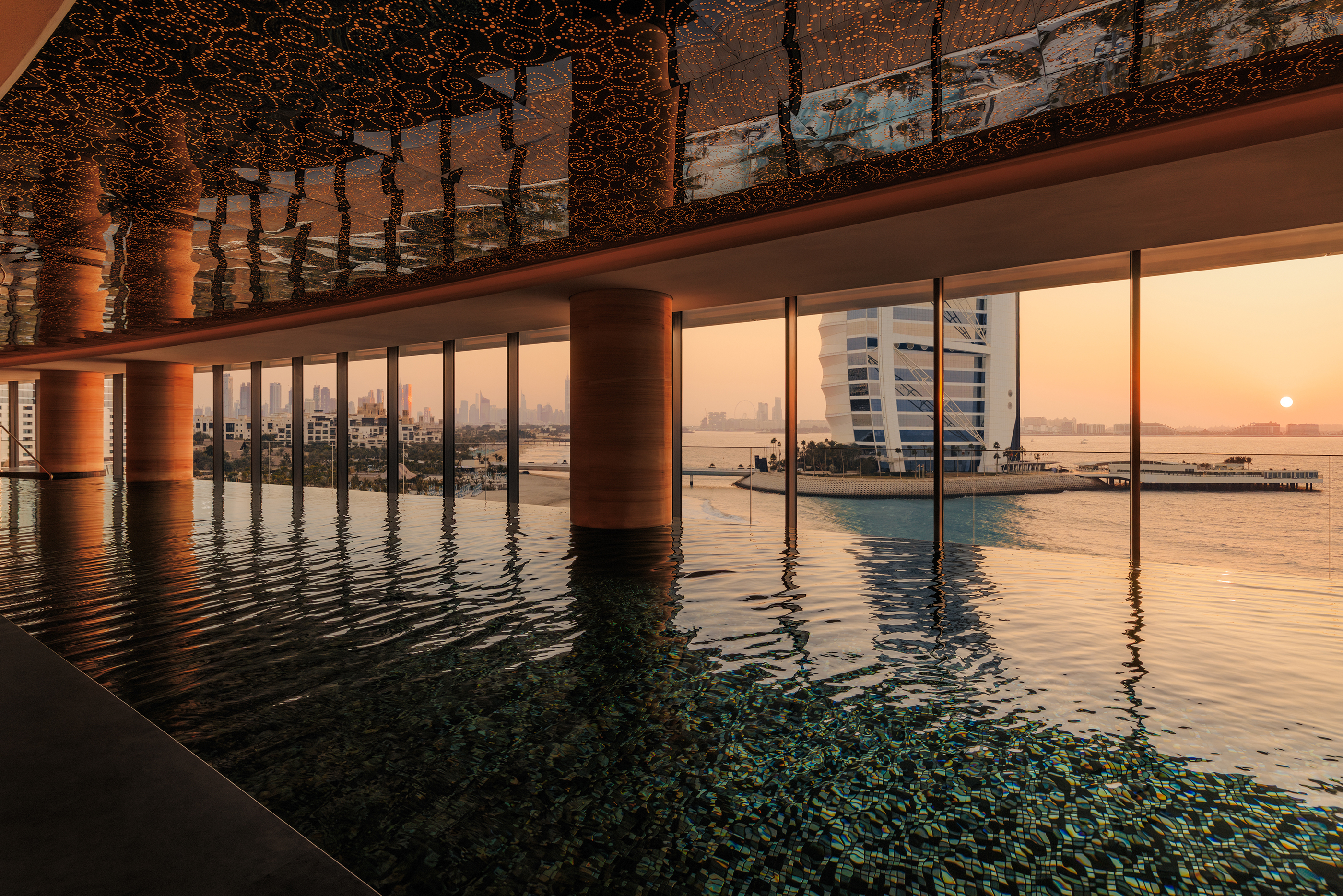 The large indoor pool of the spa at Jumeriah Marsa Al Arab with a statement ceiling and views of the Burj Al Arab
