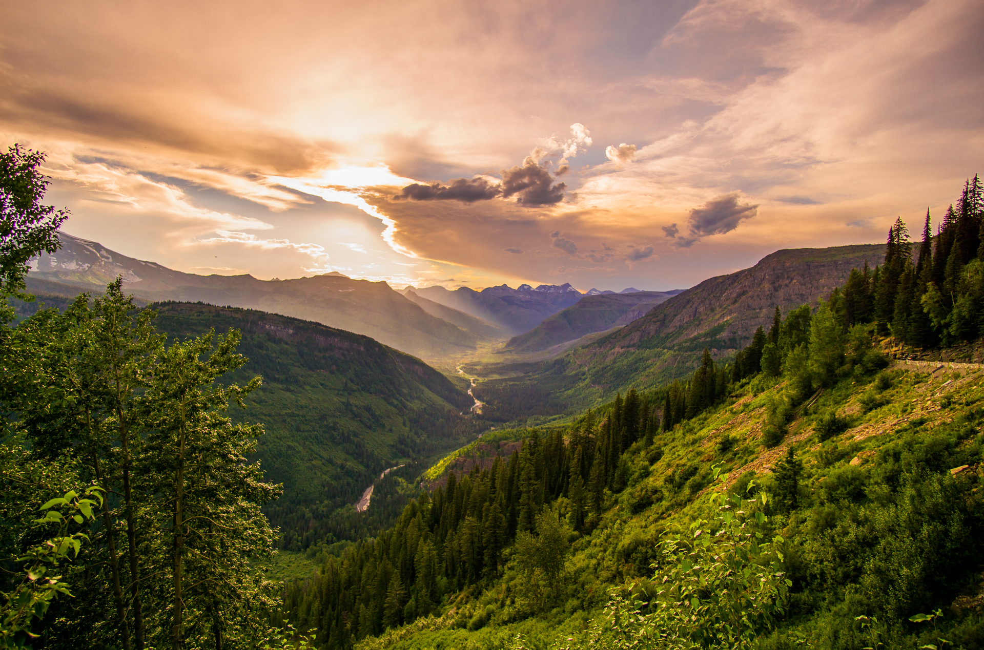 A mountain valley and river with the sun shining