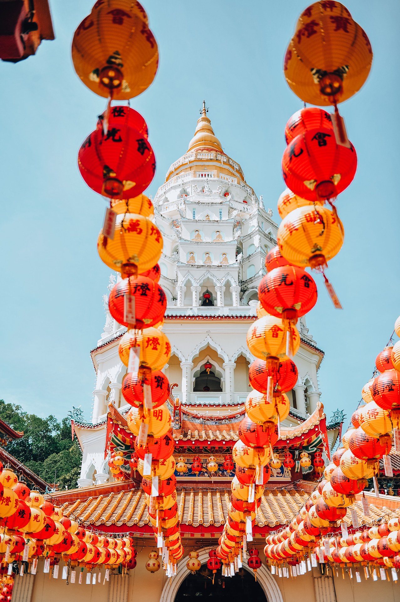 a white temple building with red and yellow lanterns