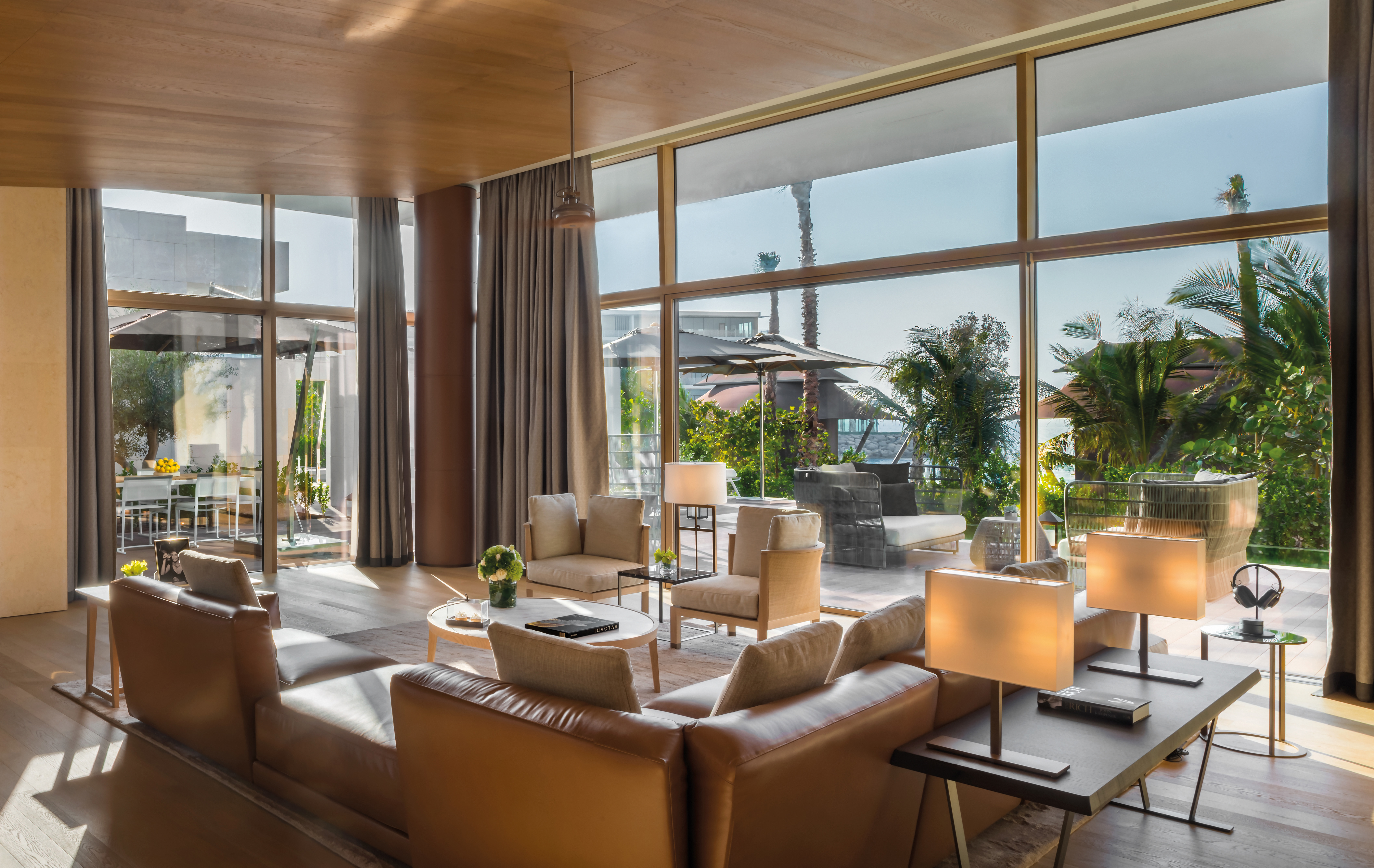 A modern lounge with plush sofa and floor to ceiling windows at Bvlgari Resort Dubai