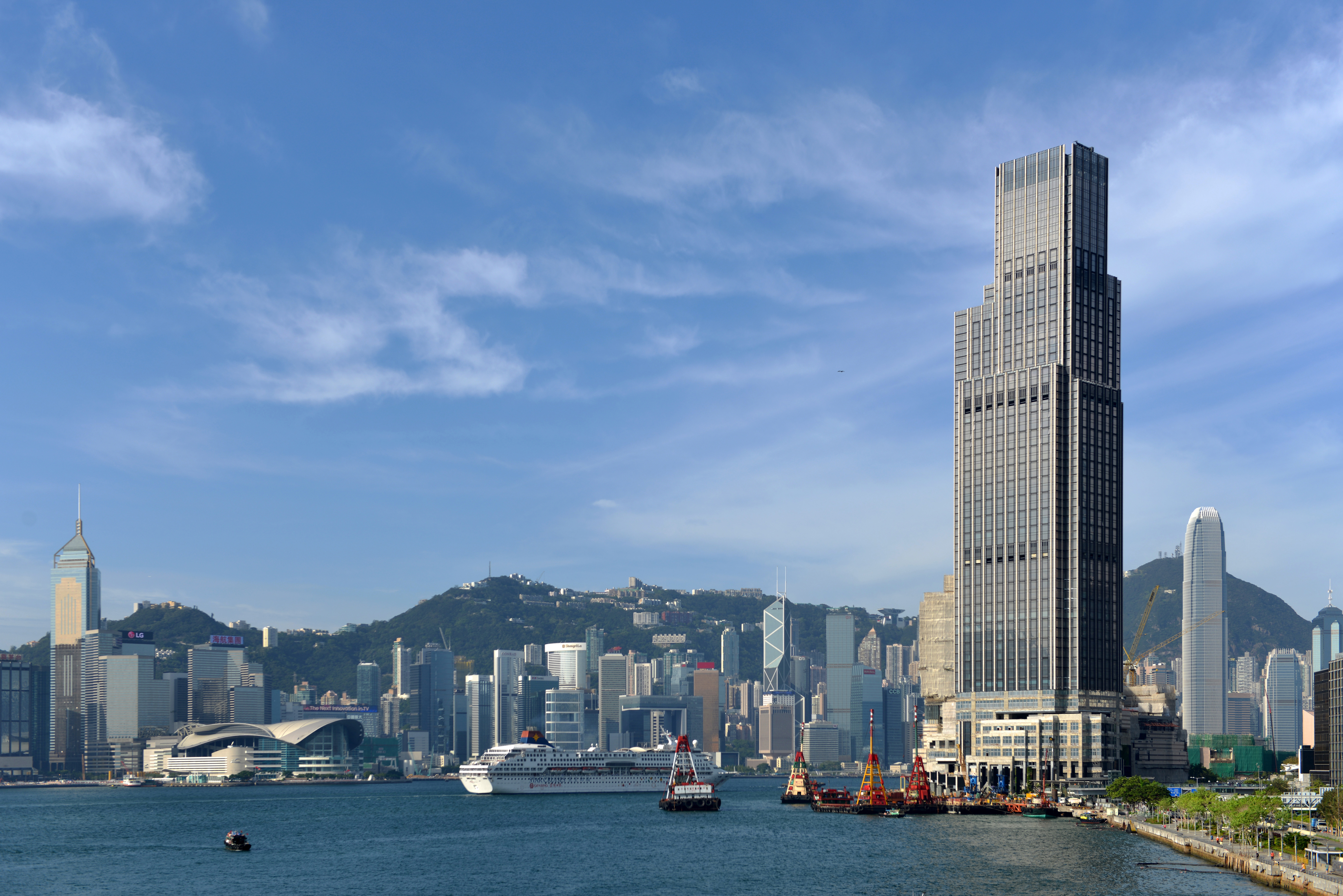 The exterior of Rosewood Hong Kong overlooking the harbour with the city skyline in the background