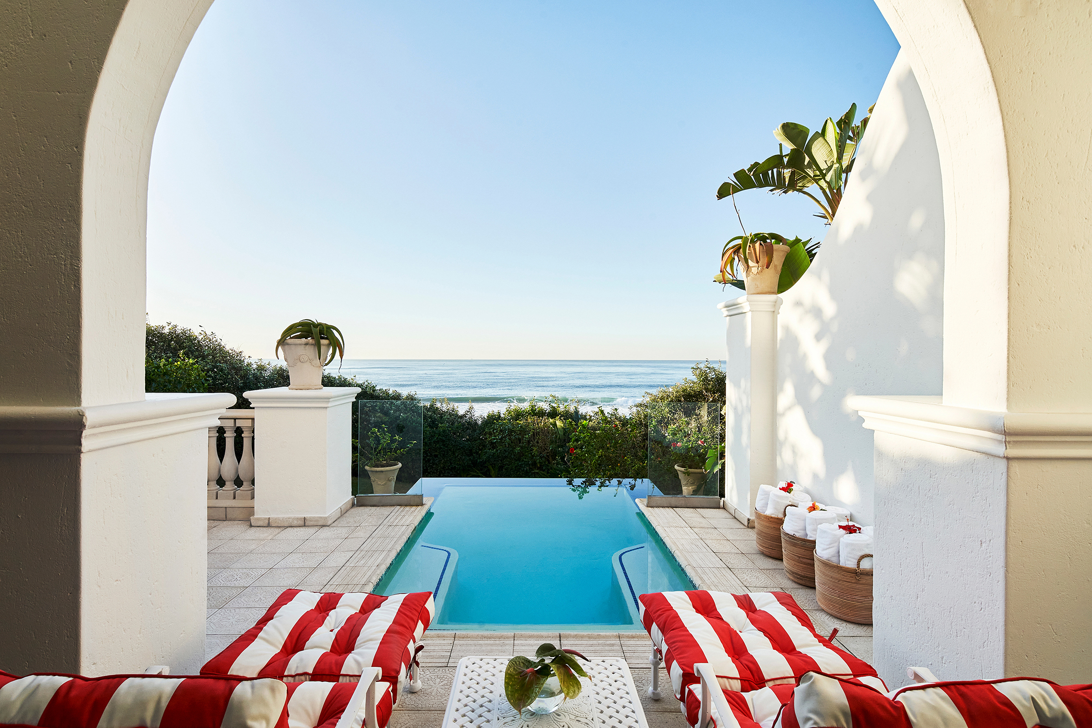 A private plunge pool at The Oyster Box with a view of the sea and red and white striped sun loungers at the top end