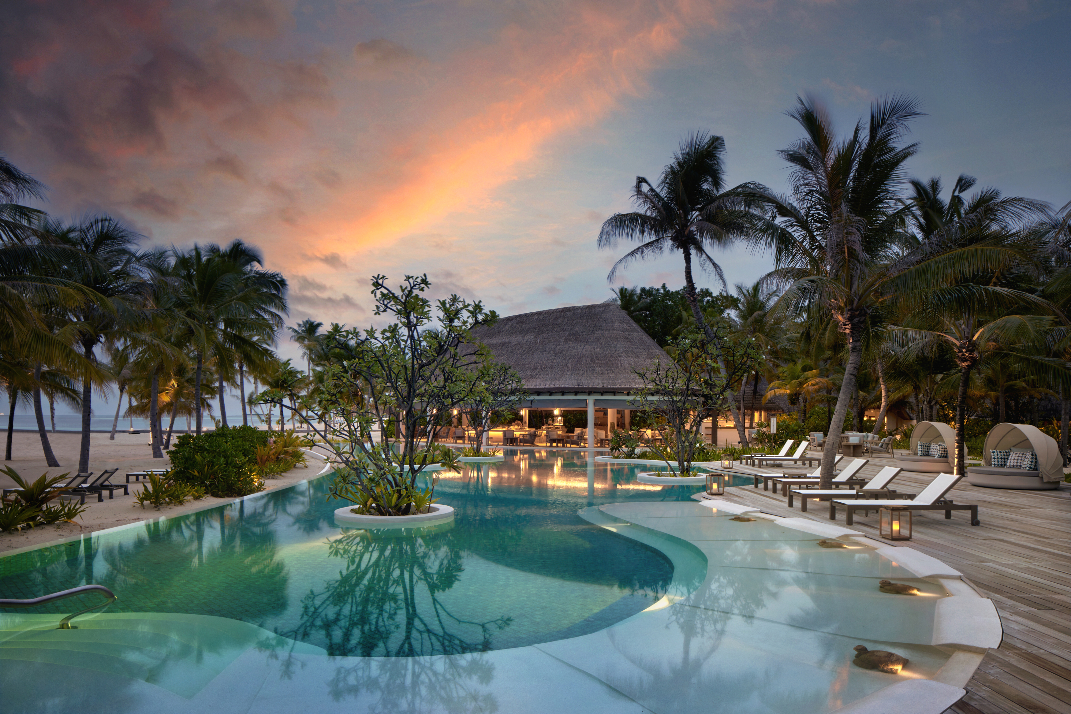 The pool next to Sip and Sand restaurant at sunset at Six Senses Kanuhura
