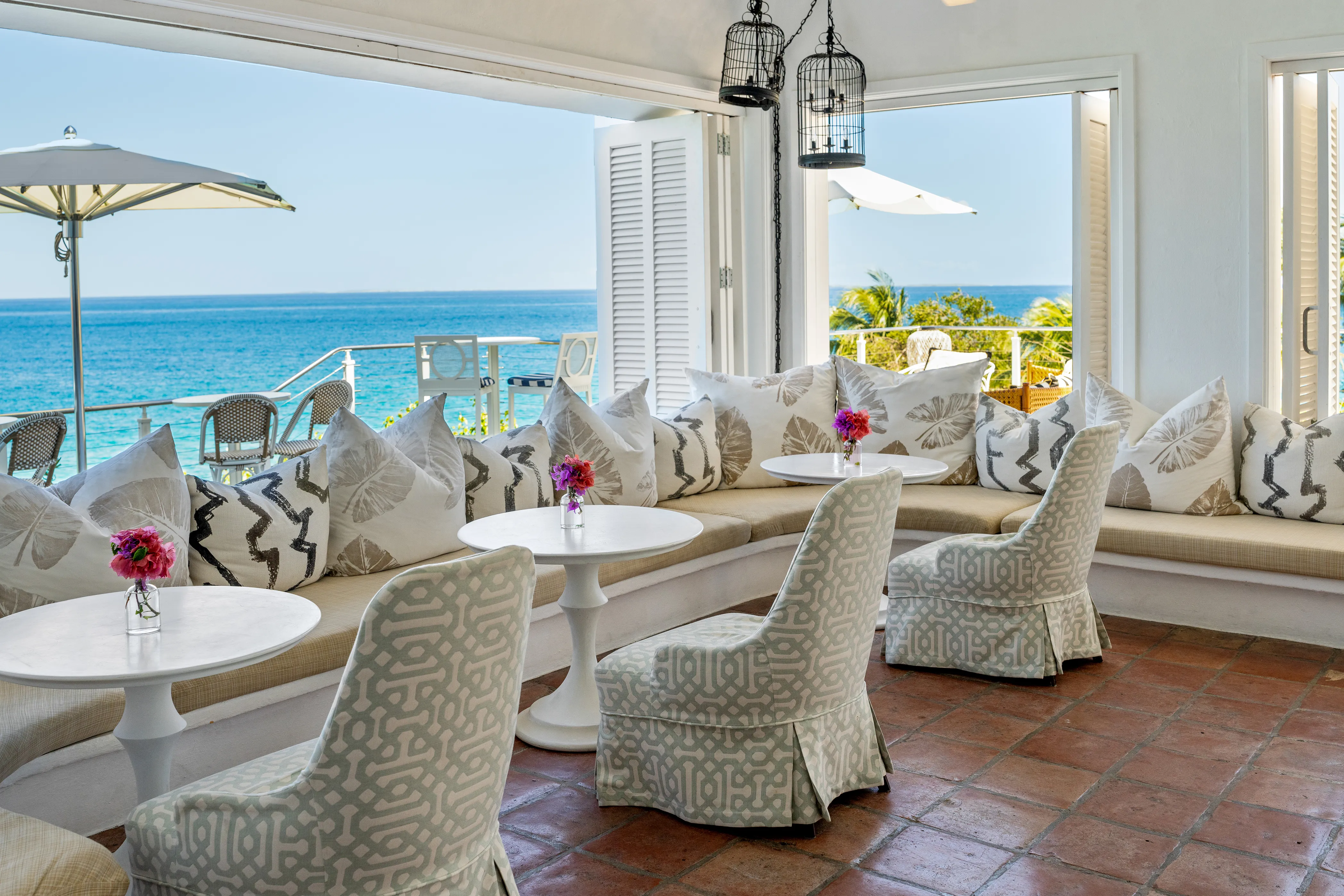 Elegant oceanfront lounge at Malliouhana Resort, Anguilla, featuring stylish Caribbean-inspired seating and panoramic views of the turquoise sea.