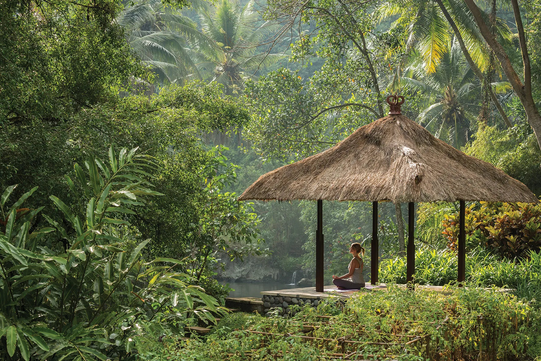 A woman meditating in a jungle pavilion at Four Seasons Bali at Sayan
