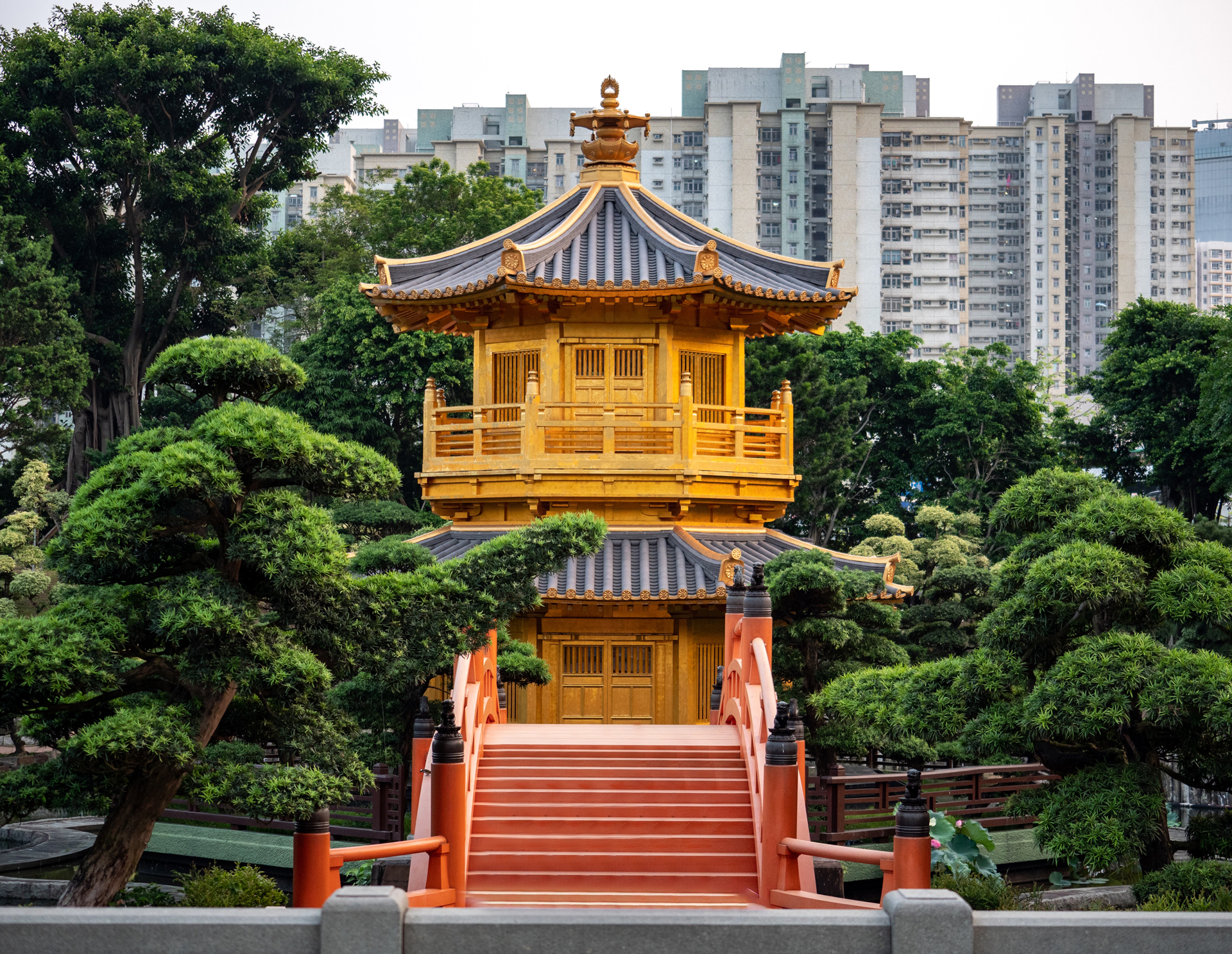 yellow pagoda with red stairs and trees in the background