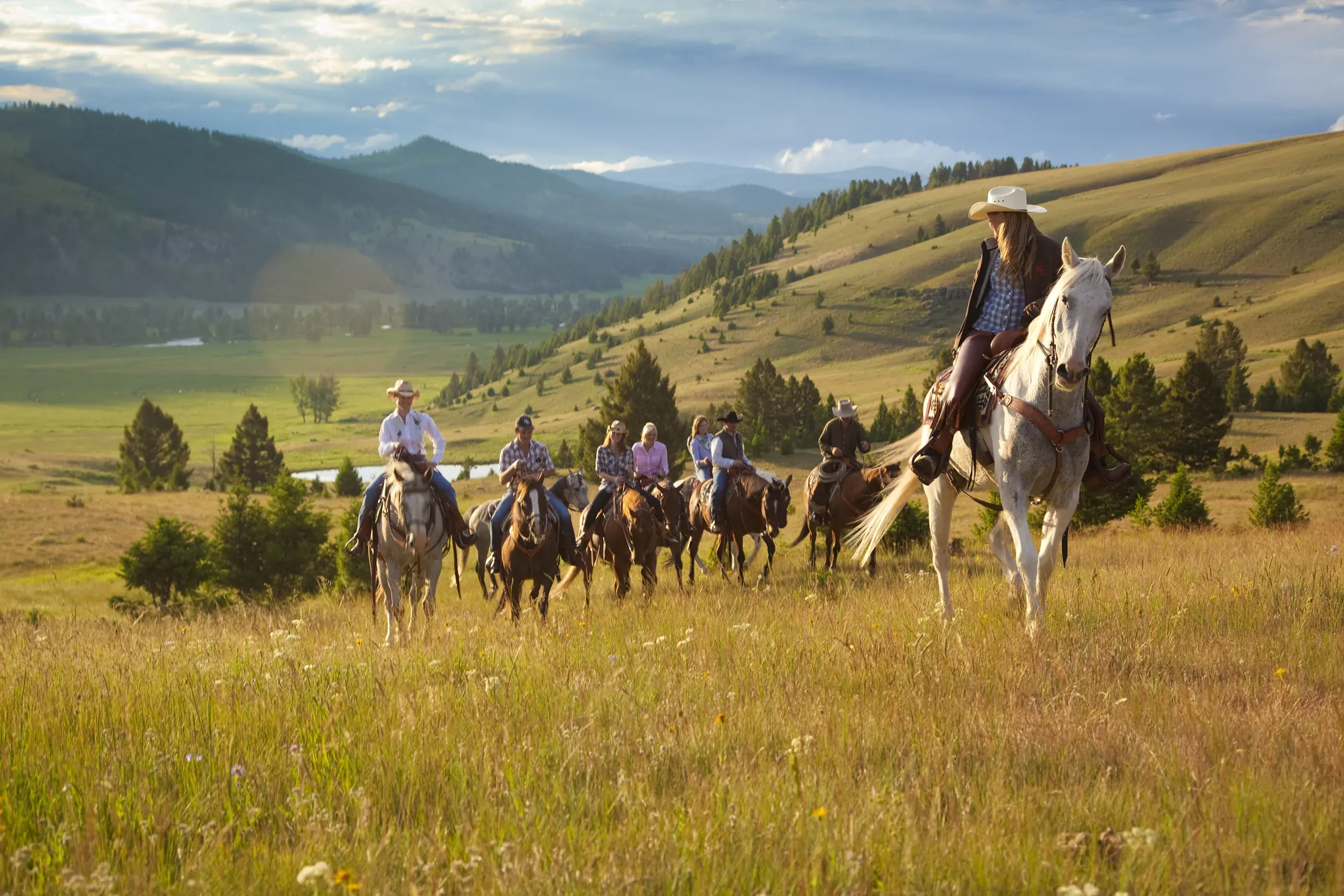 A group of guests at The Ranch at Rock Creek in Montana on a trek on horseback in a mountainous landscape 