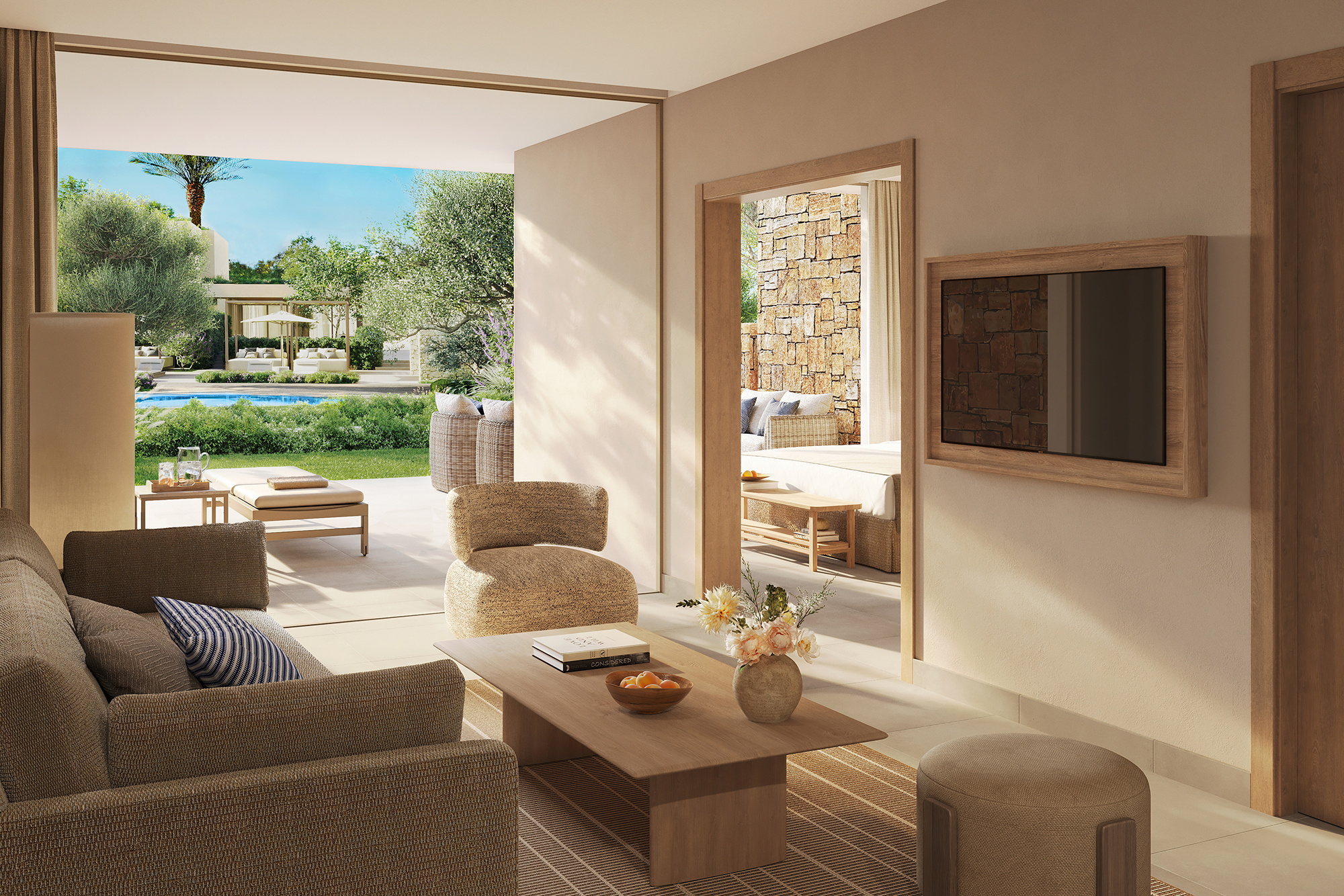 A chic neutral lounge with comfy furniture, coffee table and tv featuring sliding doors into a patio with a glimpse of a bedroom and other suite beyond