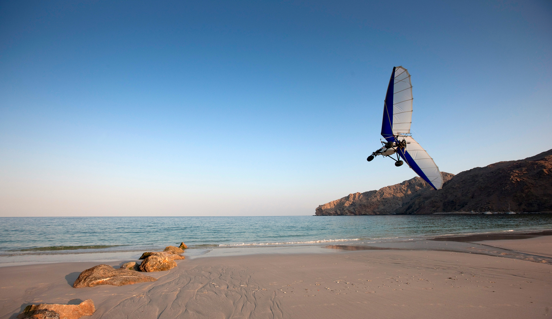 A small microlight plane just above the beach 