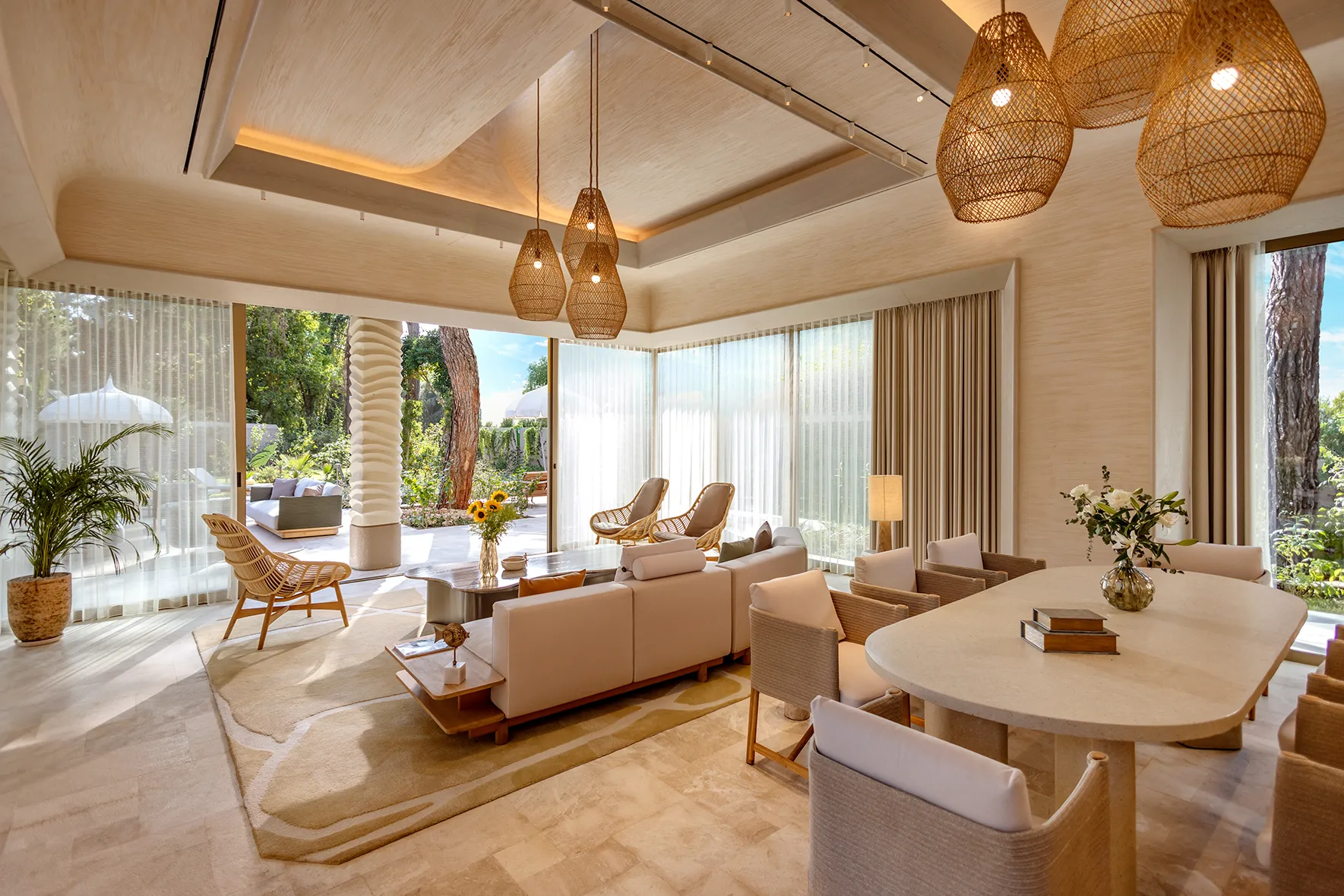 Europe, Turkey, Bijal, open plan Corner Villa lounge with seating and a dining table and floor to ceiling glass doors opening onto a terrace