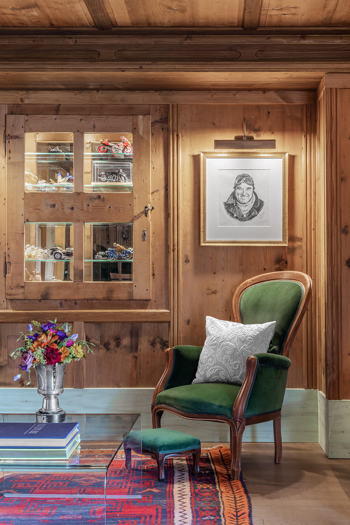 Italy ski holidays, The Dolomites, Hotel La Perla, armchair and foot rest beside a coffee table and a vase of flowers