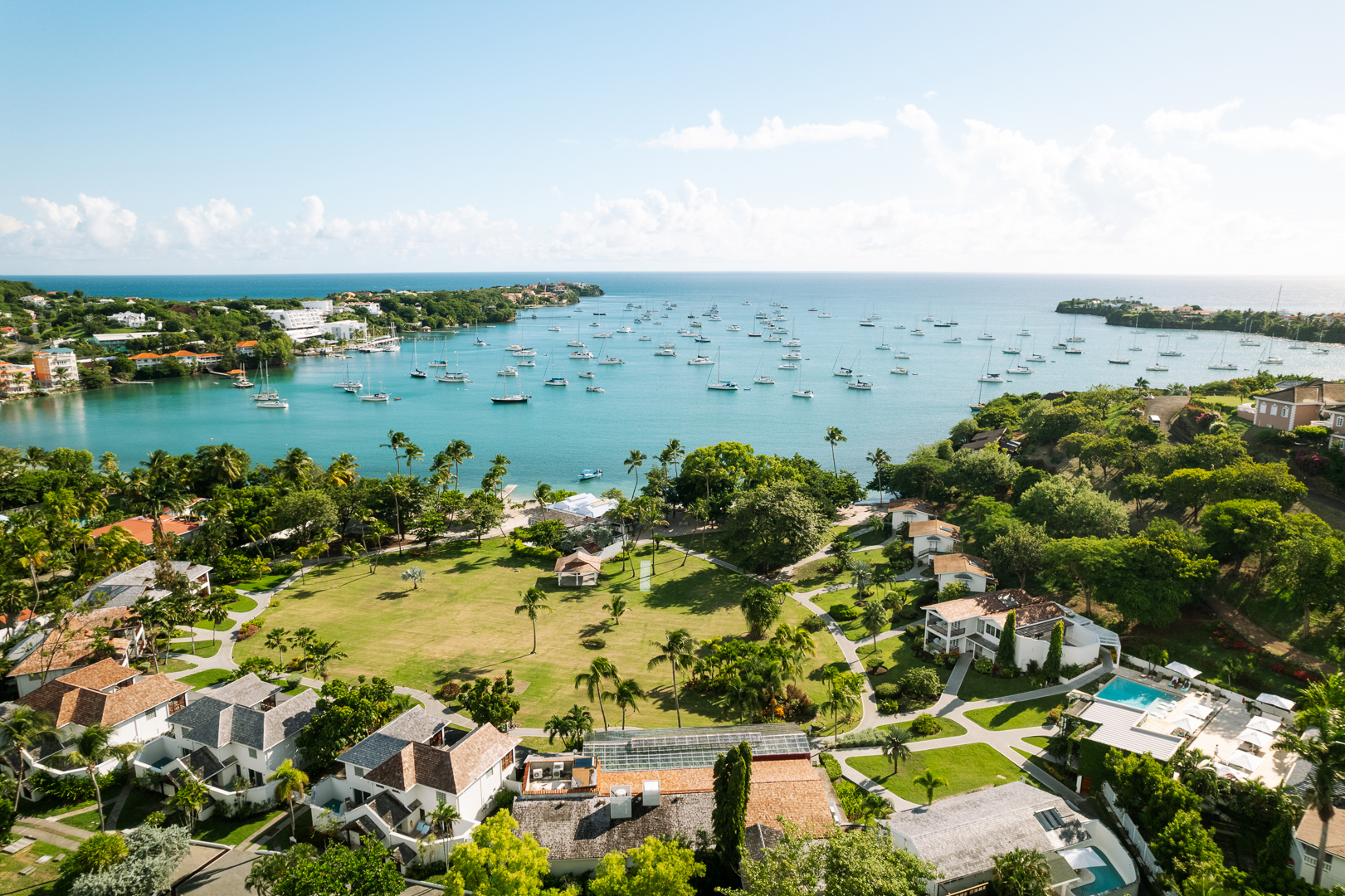 A sweeping yacht-studded bay edged by the gardens and buildings of Calabash Hotel