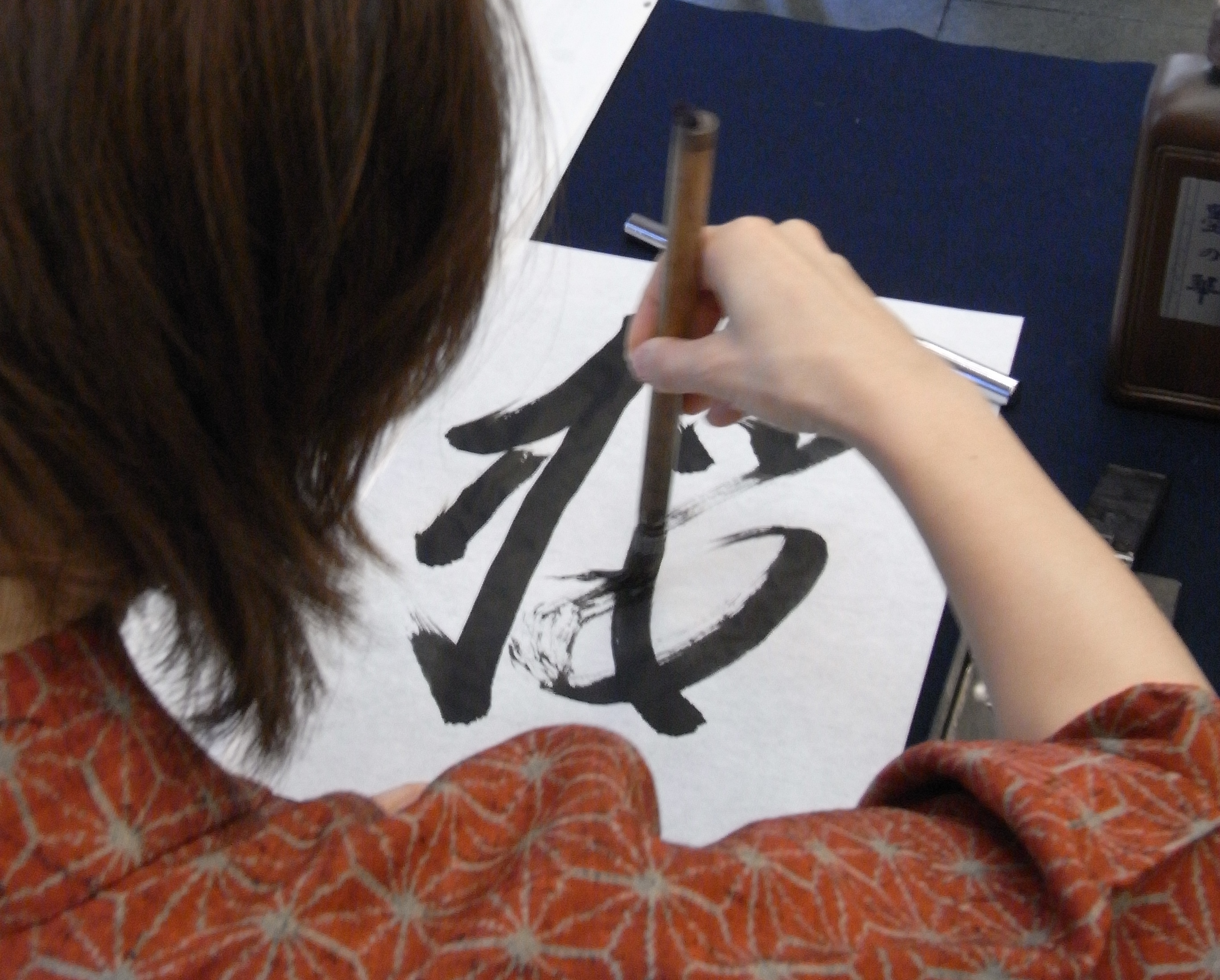 A person practicing traditional Japanese caligraphy