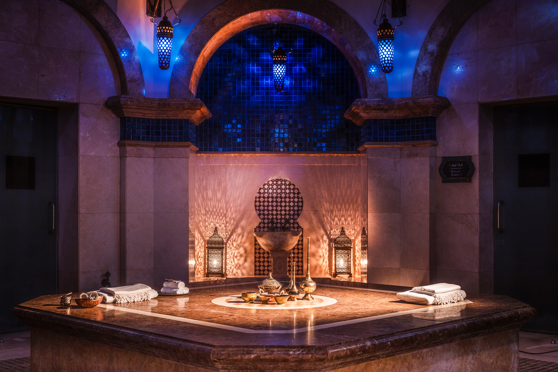A dark spa room with towels and blue lights
