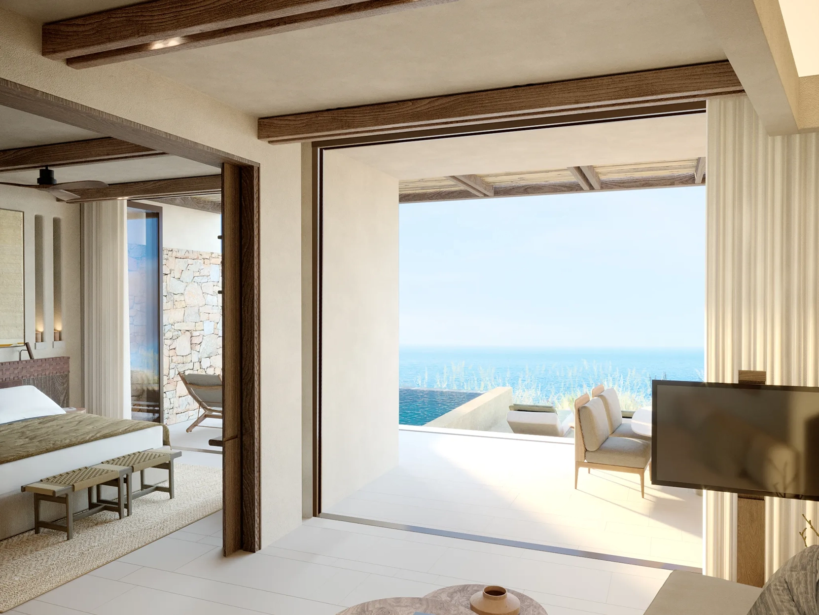 A view looking from a suite living room to the bedroom and a private terrace with plunge pool and sea view