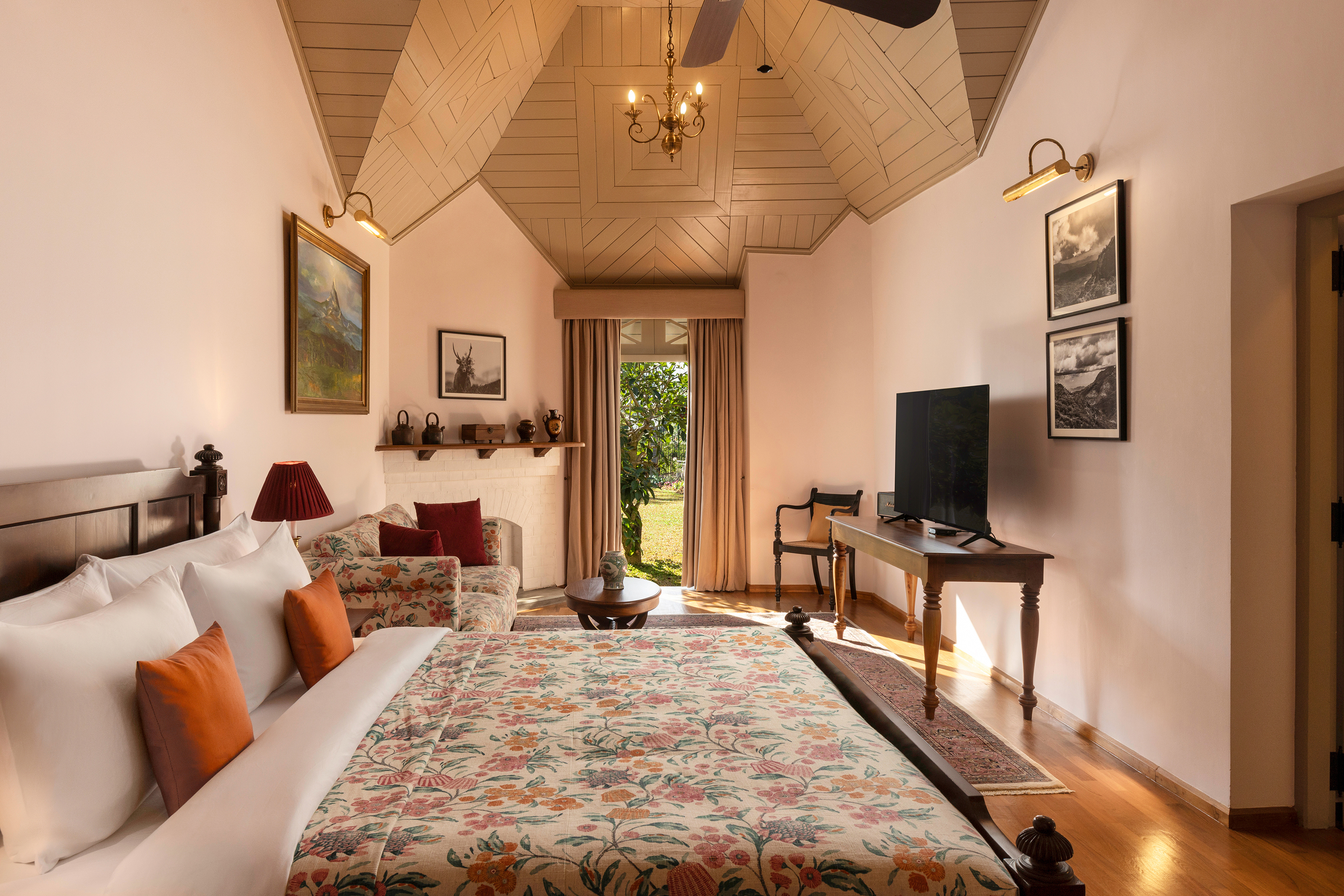 A Pekoe Suite at Uga Halloowella featuring a comfy bed with floral sheets, cottage-style decor and peaked wood-panelled ceilings