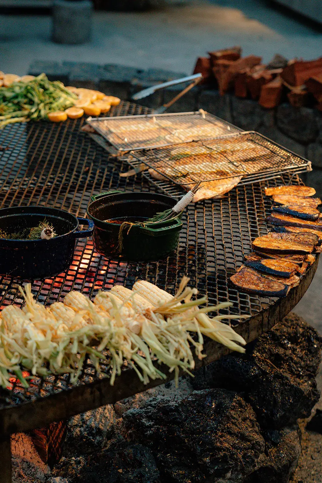 A variety of local food being grilled on a large barbecue 