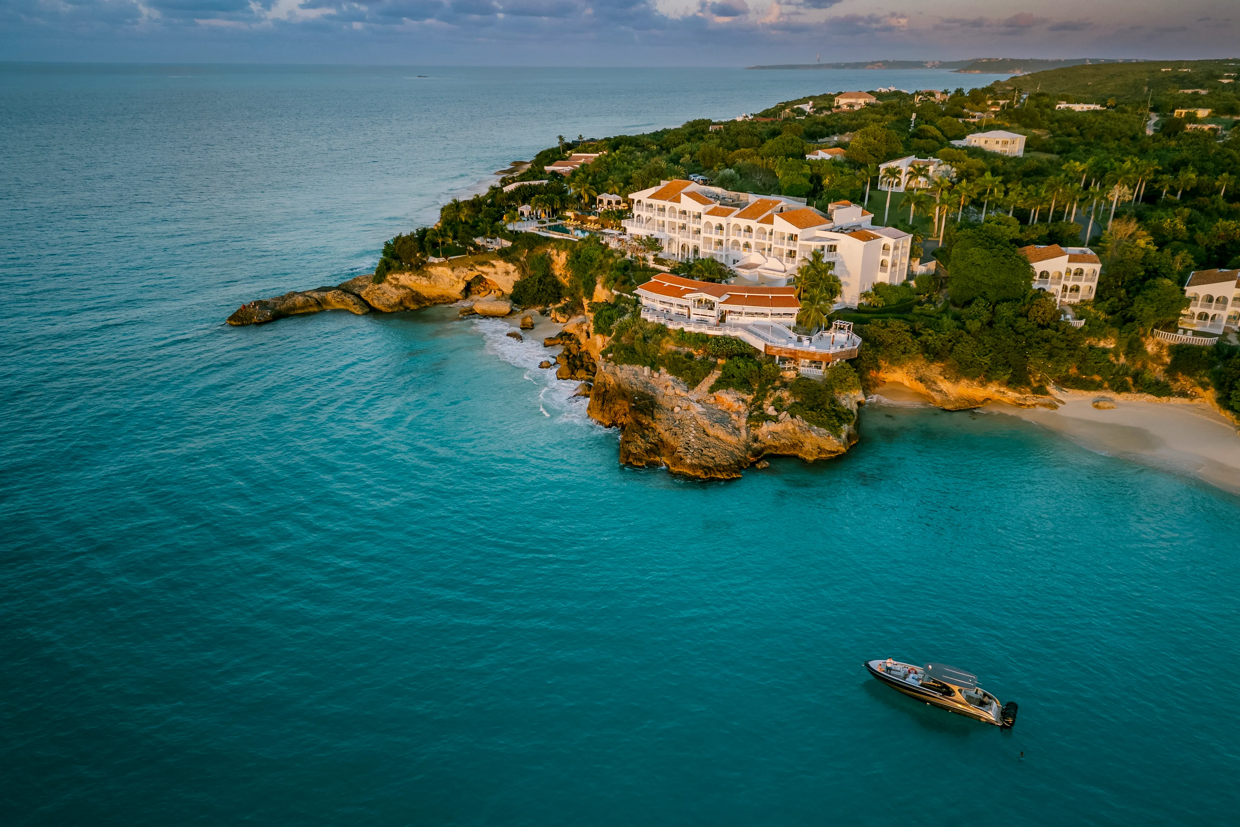 Luxury cliffside view of Malliouhana Resort in Anguilla overlooking turquoise Caribbean waters, secluded beaches, and stunning island coastline.