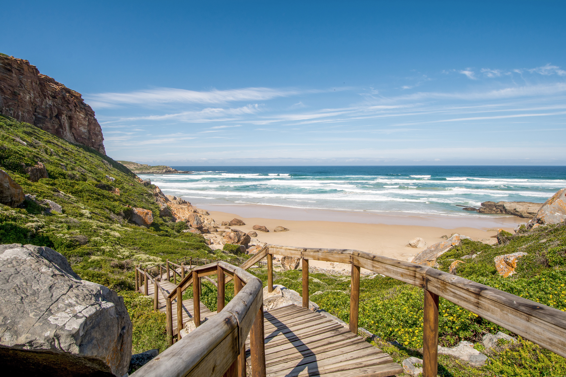 A wooden walkway that leads down to the beach