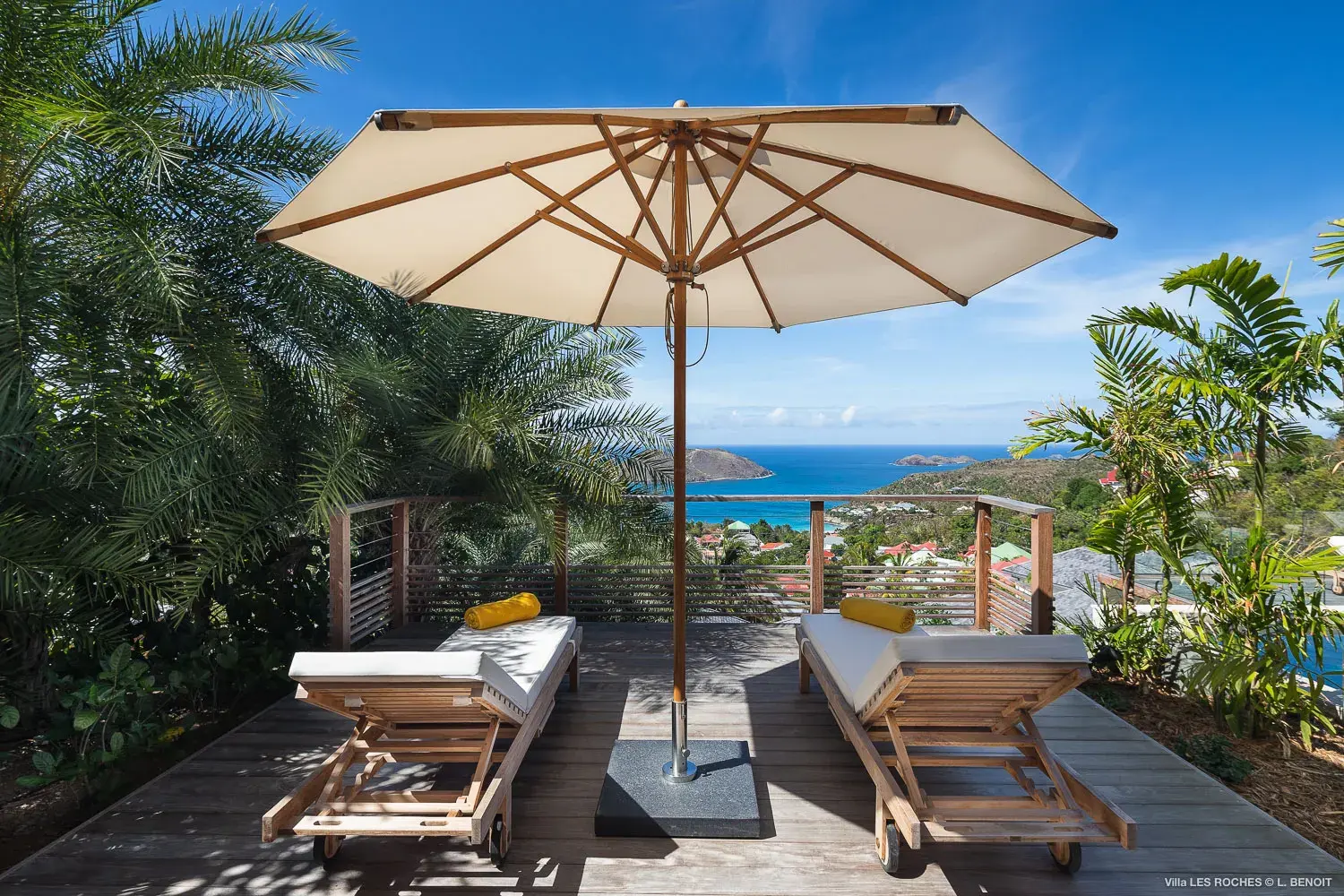 Scenic sun lounger deck at Les Roches Villa in St Barths with umbrella shade, tropical greenery and panoramic Caribbean Sea views.