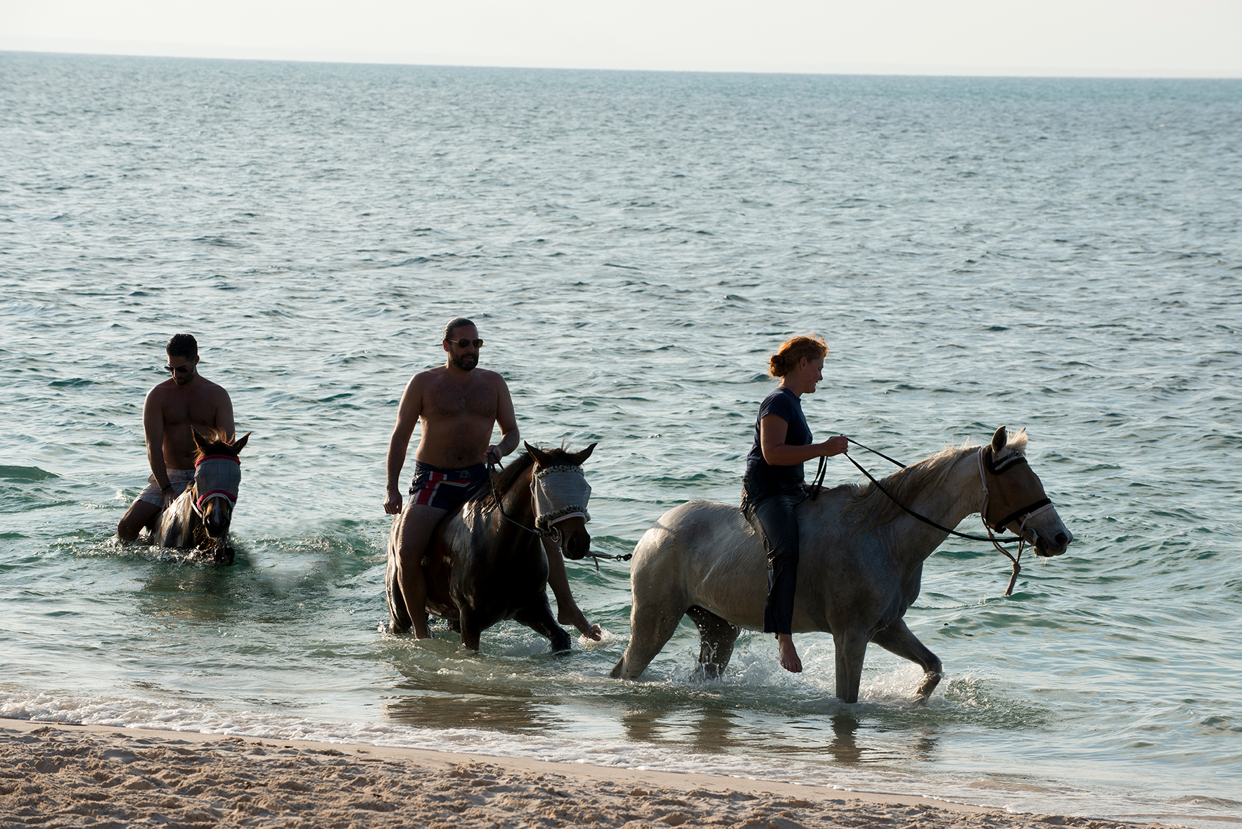 People on horses in the sea