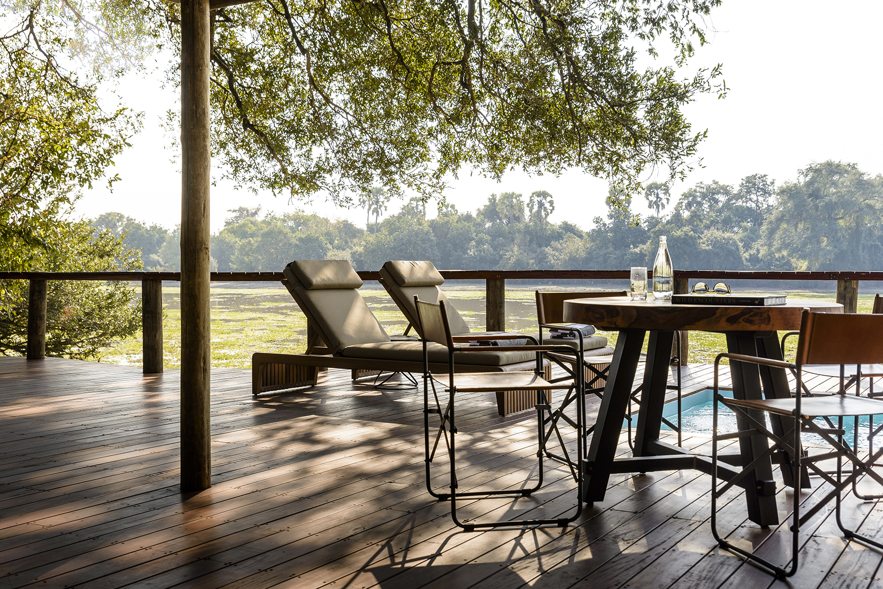 Africa, Zambia, Sungani Lodge, a table, chairs and sunloungers beside a pool
